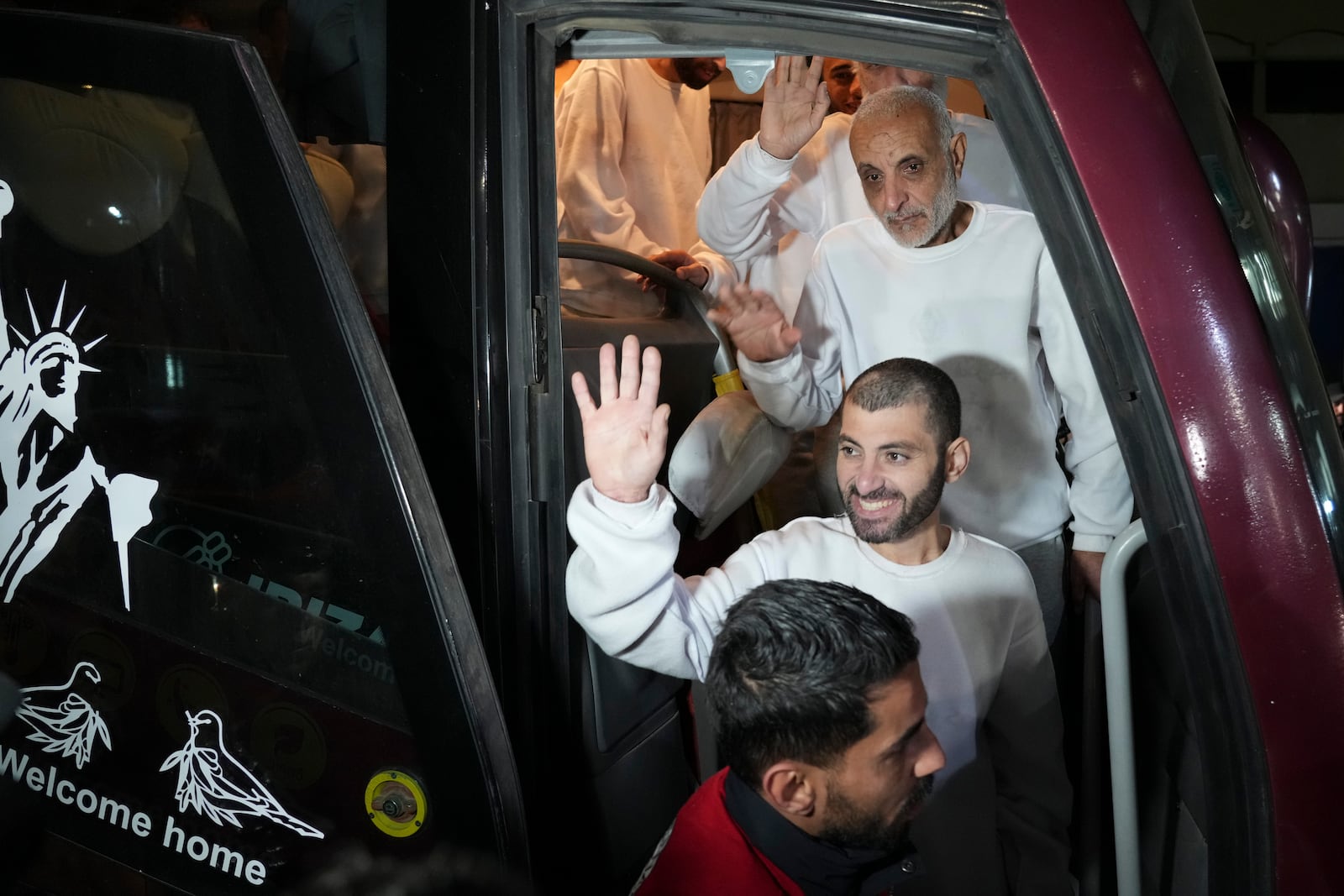 Freed Palestinian prisoners wave from a bus as they arrive in the Gaza Strip after being released from an Israeli prison following a ceasefire agreement between Hamas and Israel in Khan Younis, Gaza Strip, Thursday, Feb. 27, 2025. (AP Photo/Abdel Kareem Hana)