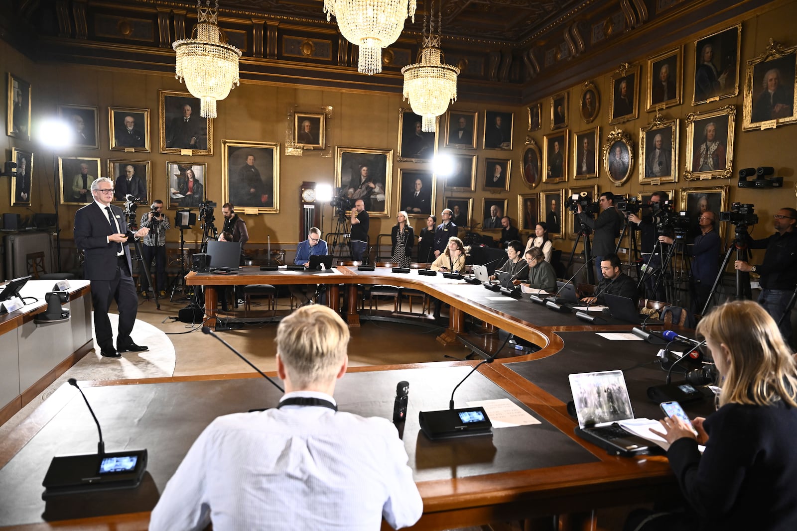 Journalists listen when Jan Teorell of the Nobel assembly announces the Nobel memorial prize in economics winners during a press meeting at the Royal Swedish Academy of Sciences in Stockholm, Sweden, Monday Oct. 14, 2024. (Christine Olsson/TT News Agency via AP)