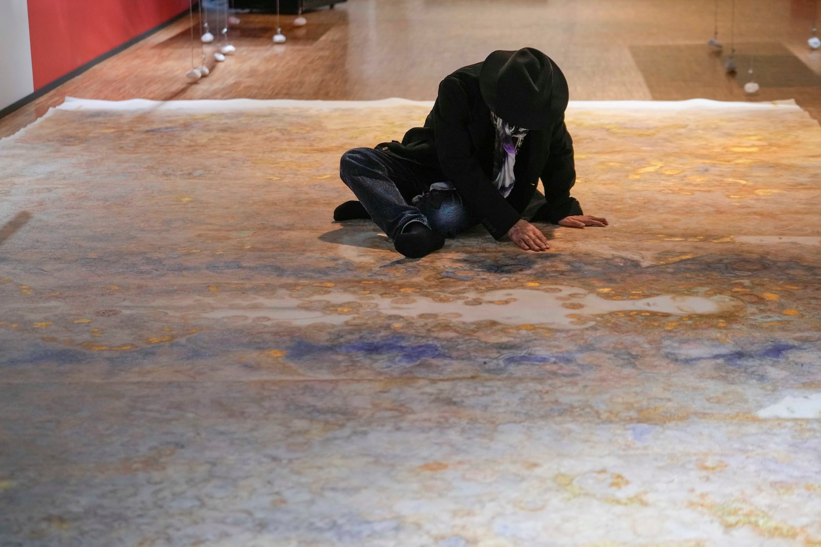 Artist Yoshitaka Amano sits on one of his creations during the press preview of the exhibition "Amano Corpus Animae", celebrating his 50-year-long career, at the Fabbrica del Vapore, in Milan, Italy, Tuesday, Nov. 12, 2024. (AP Photo/Luca Bruno)