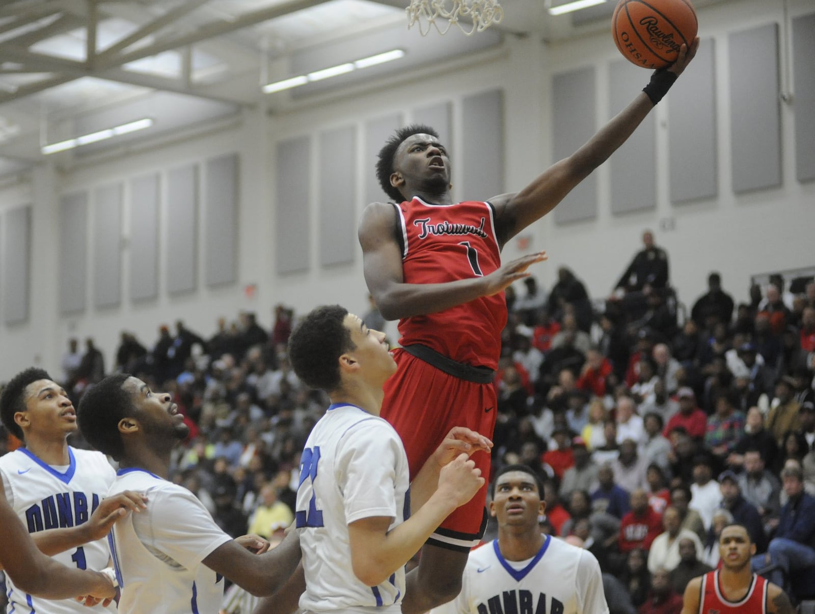 Trotwood’s Amari Davis soars above Dunbar defenders to score. Trotwood-Madison defeated Dunbar 83-54 in a boys high school basketball D-II regional final at Fairmont’s Trent Arena on Saturday, March 18. MARC PENDLETON / STAFF