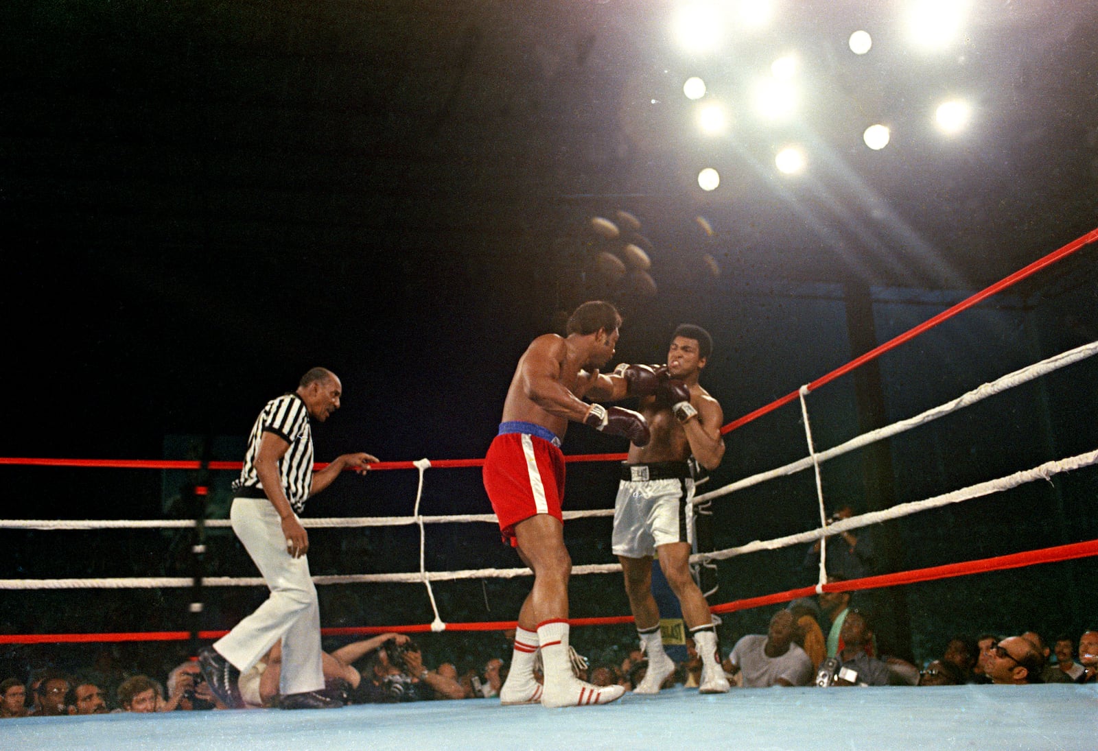 FILE - Challenger Muhammad Ali is hit with a left jab by defending world champion George Foreman during the WBA/WBC championship bout in Kinshasa, Zaire, on Oct. 30, 1974. (AP Photo, File)