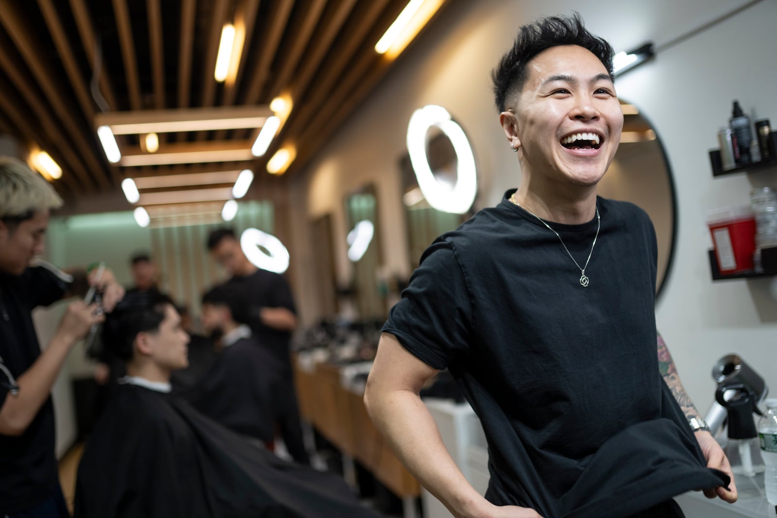 Barbers work on their clients at 12 Pell, a local barbershop in Manhattan's Chinatown, Thursday, Jan. 25, 2024, in New York. Clients are drawn by 12 Pell's social media, in which the young, predominantly Asian American barbers are making a study of cool, offering consultations on style and cut, what's fashionable and not. (AP Photo/John Minchillo)