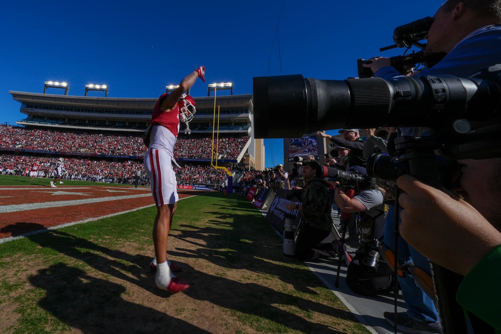 Oklahoma wide receiver Zion Kearney celebrates in front of photographers after scoring a touchdown on a pass from quarterback Michael Hawkins Jr. during the first half of the Armed Forces Bowl NCAA college football game against Navy, Friday, Dec. 27, 2024, in Fort Worth, Texas. (AP Photo/Julio Cortez)