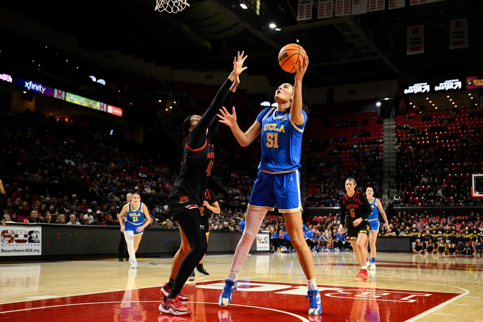 UCLA center Lauren Betts (51) goes to the basket against Maryland forward Amari DeBerry, front left, during the first half of an NCAA college basketball game, Sunday, Jan. 26, 2025, in College Park, Md. (AP Photo/Nick Wass)