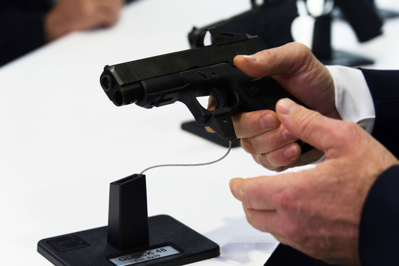 A man handles a Glock pistol at the biennial International Defense Exhibition and Conference arms show in Abu Dhabi, United Arab Emirates, Monday, Feb. 17, 2025. (AP Photo/Jon Gambrell)