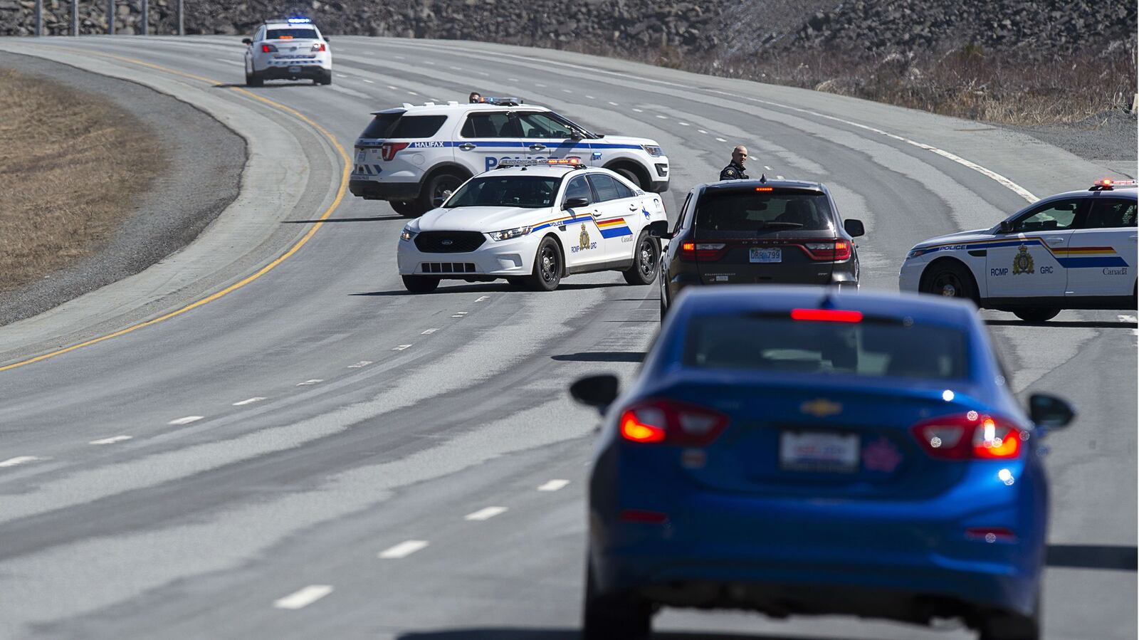 Royal Canadian Mounted Police officers block off a roadway in Enfield, Nova Scotia, Sunday April 19, 2020. Multiple people are dead, including the alleged shooter, following a 12-hour rampage across the province of Nova Scotia. It is the deadliest mass shooting in Canada in 30 years. (Andrew Vaughan/The Canadian Press via AP)