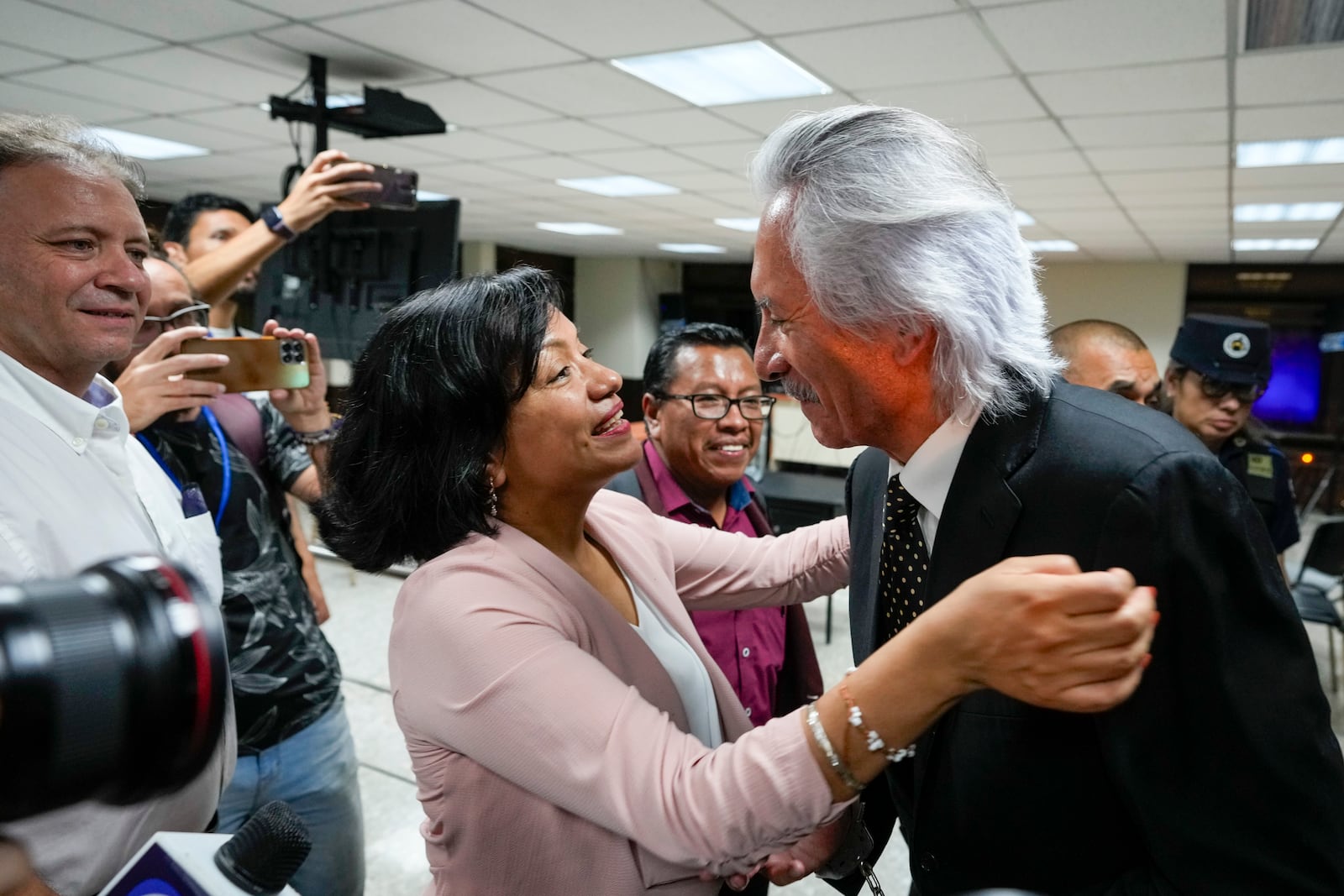 A lawyer greets Guatemalan journalist Jose Ruben Zamora, founder of El Periodico newspaper, jailed for more than two years on money laundering charges, as he exits a courthouse after a judge granted him house arrest, in Guatemala City, Friday, Oct. 18, 2024. (AP Photo/Moises Castillo)