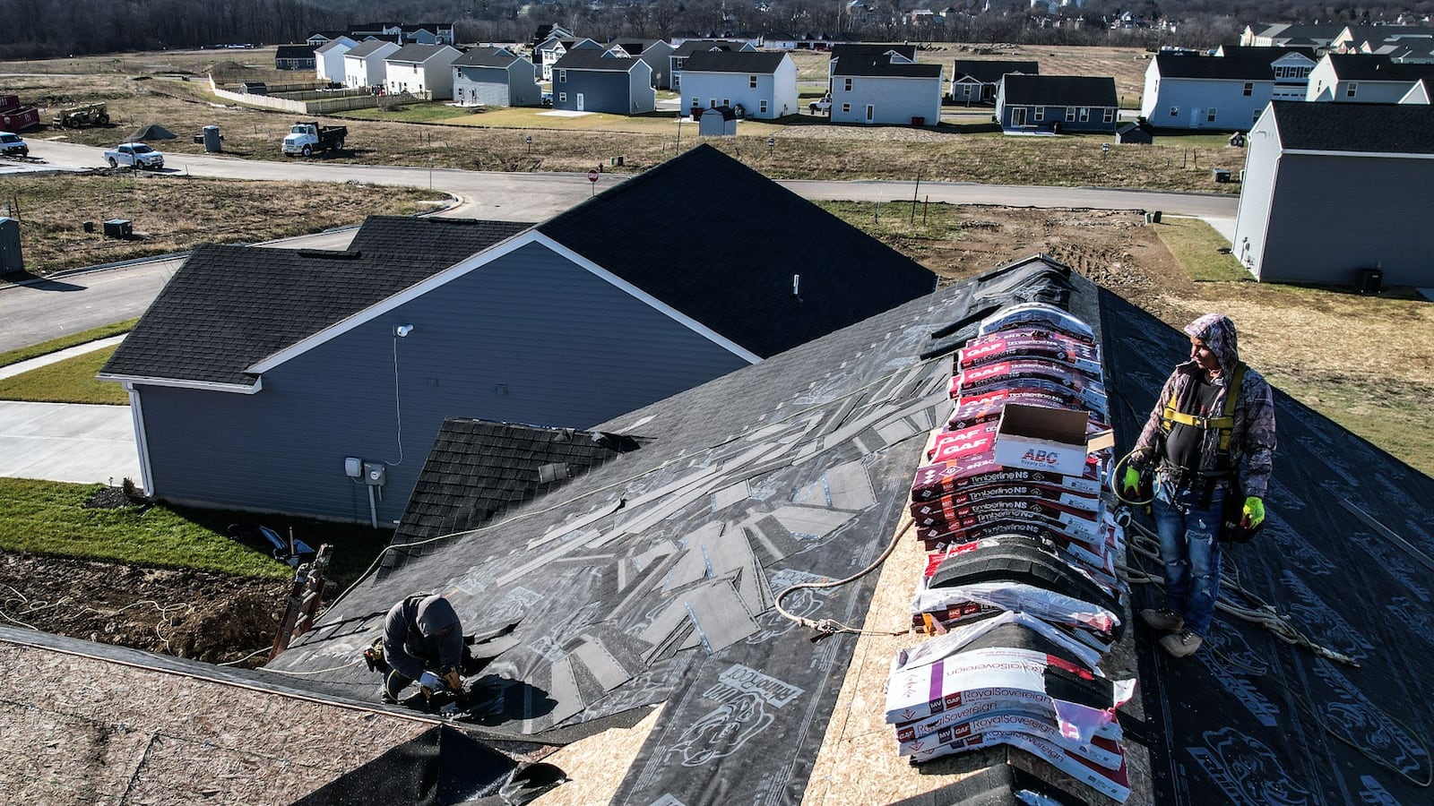 Roofers work on a house in a Ryan Homes development near Rachel Ann Blvd. in West Milton Tuesday December 19., 2023.