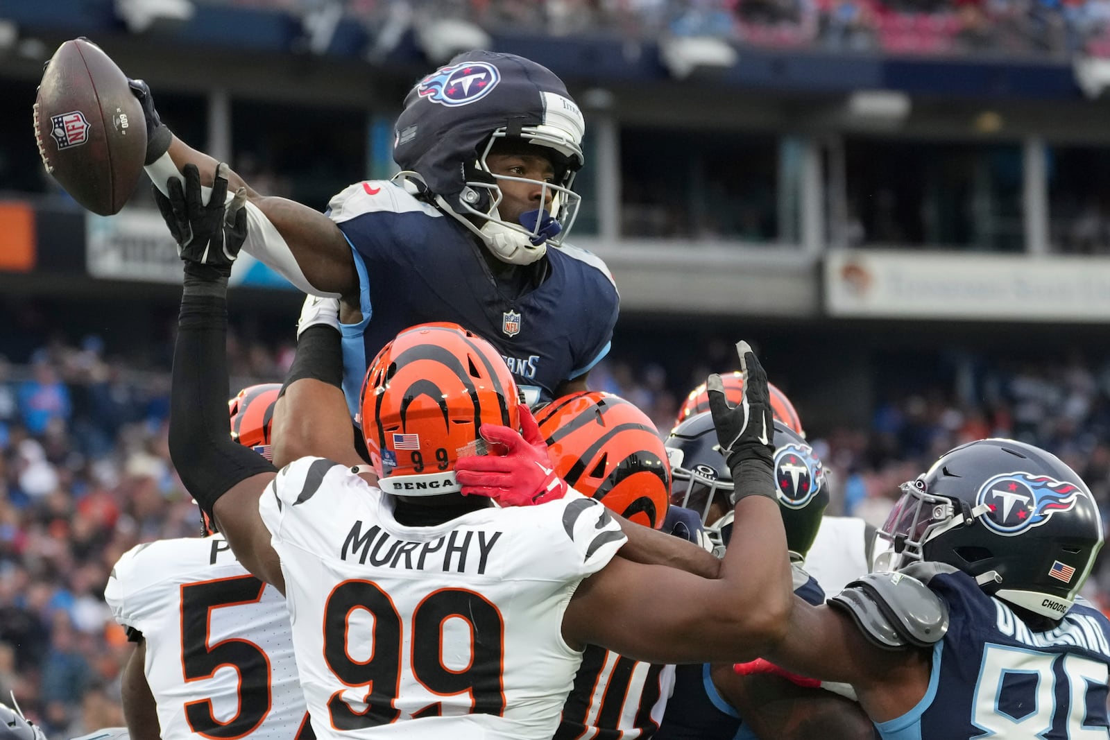 Tennessee Titans running back Tyjae Spears (2) scores a touchdown over the Cincinnati Bengals defense during the first half of an NFL football game Sunday, Dec. 15, 2024, in Nashville, Tenn. (AP Photo/George Walker IV)