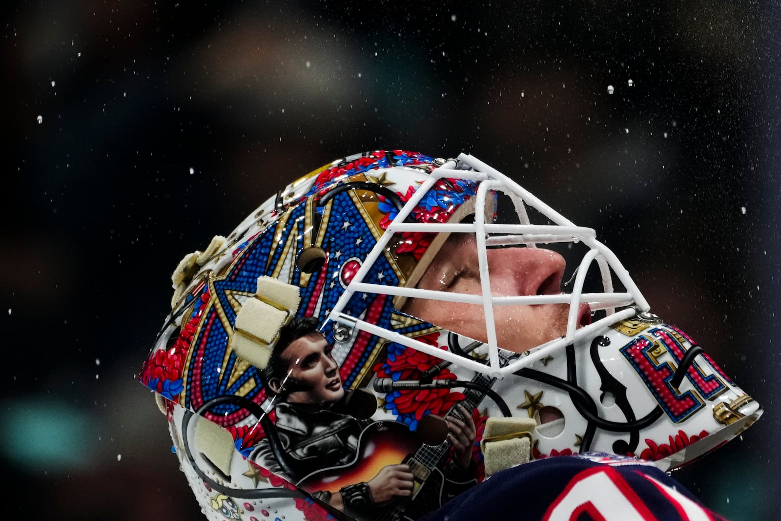 Columbus Blue Jackets goaltender Elvis Merzlikins sprays water in the air during a timeout during the second period of an NHL hockey game against the Seattle Kraken, Tuesday, Nov. 12, 2024, in Seattle. (AP Photo/Lindsey Wasson)