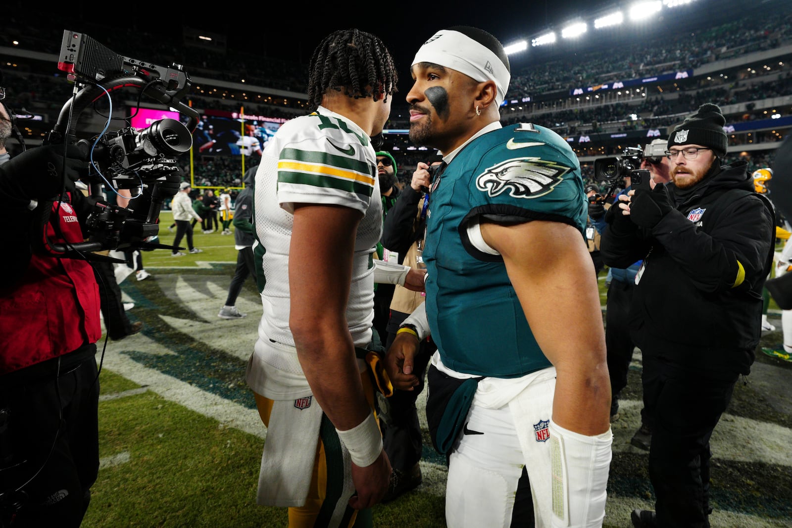 Green Bay Packers quarterback Jordan Love (10) and Philadelphia Eagles quarterback Jalen Hurts (1) walk away after greeting each other after an NFL wild-card playoff football game Sunday, Jan. 12, 2025, in Philadelphia. (AP Photo/Derik Hamilton)