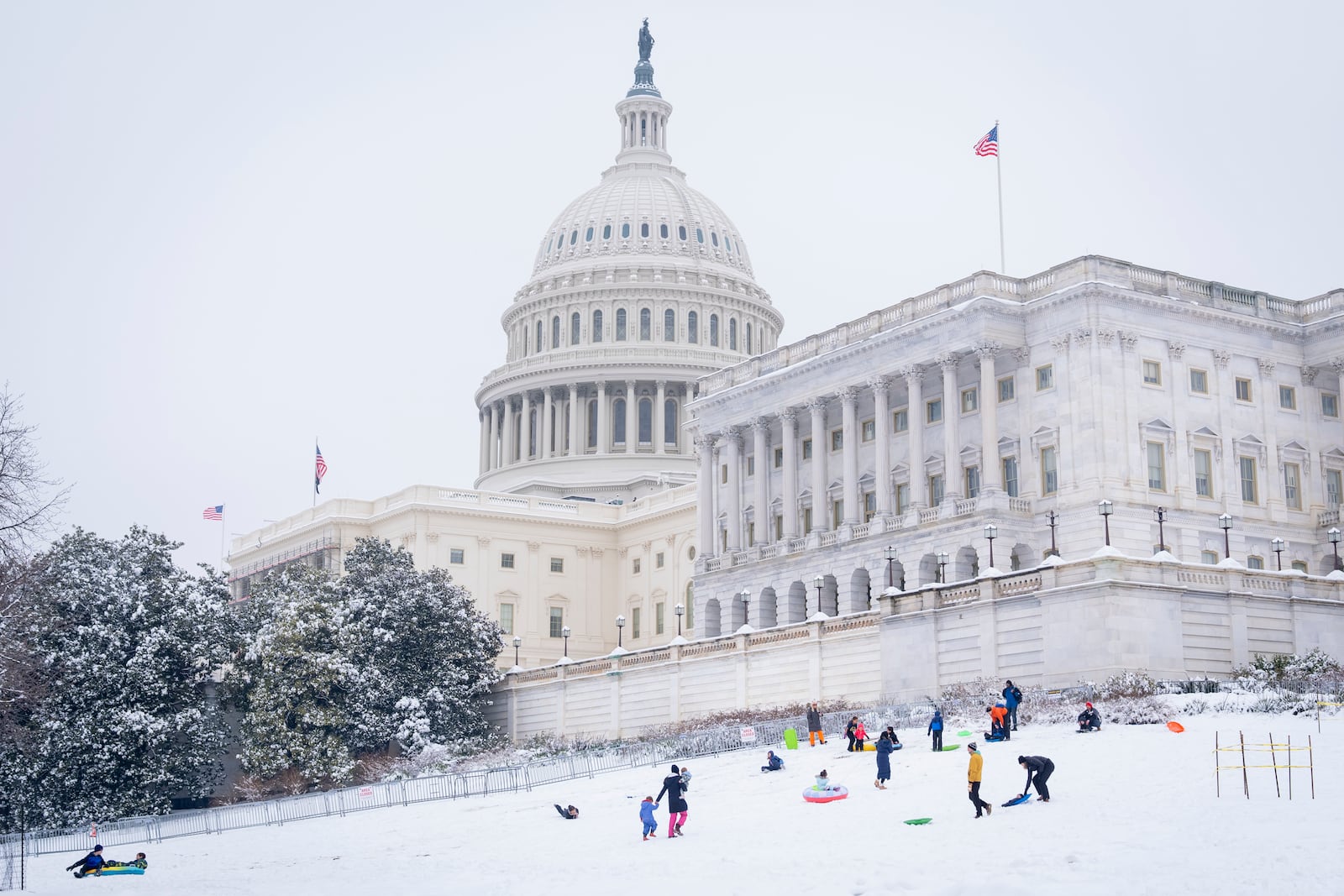 Families enjoy the snow by the Capitol, Wednesday, Feb. 12, 2025, as they sled after a snowstorm in Washington. (AP Photo/Jacquelyn Martin)