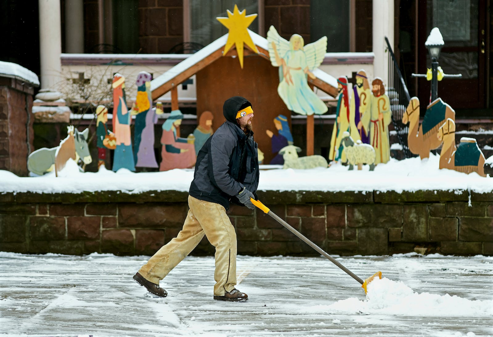 Josh Williams, of Johnstown, shovels snow from the walkway at First United Methodist Church on Vine Street in downtown Johnstown, Pa., Monday, Jan. 6, 2025. (Thomas Slusser/The Tribune-Democrat via AP)