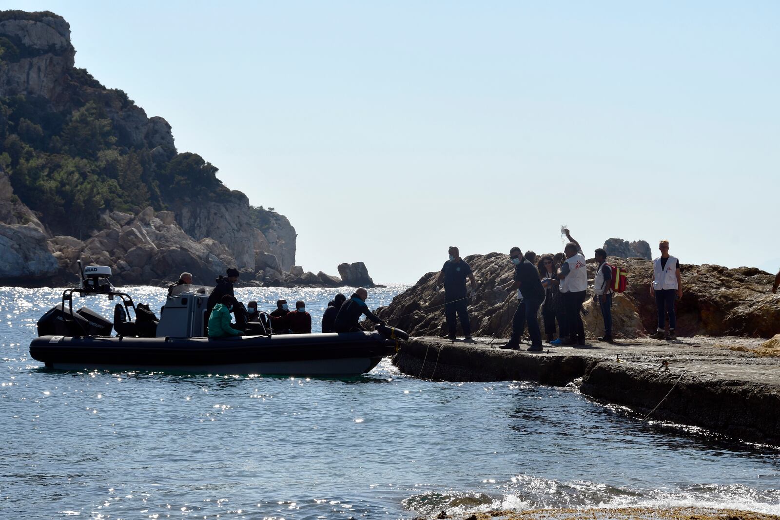 Members of Doctors Without Borders and coast guards officers help a pregnant woman to embark on a vessel with other survivors, after a boat carrying migrants ran into trouble off the coast of the eastern Aegean Sea island of Samos, Greece, on Monday, Sept. 23, 2024. (AP Photo/Michael Svarnias)