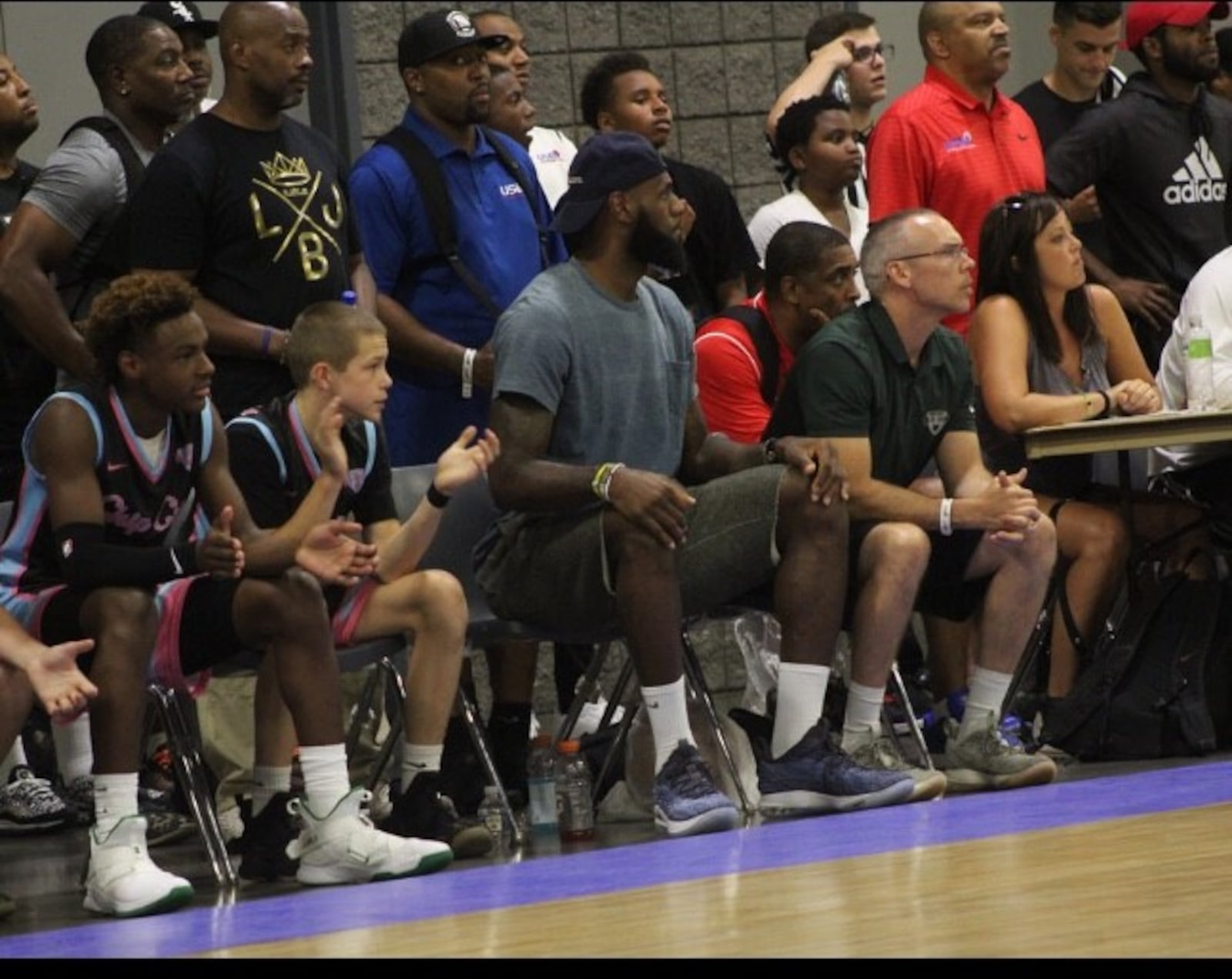 From left, Bronny James, Gabe Cupps, LeBron James and Brook Cupps on the bench during an AAU game. CONTRIBUTED