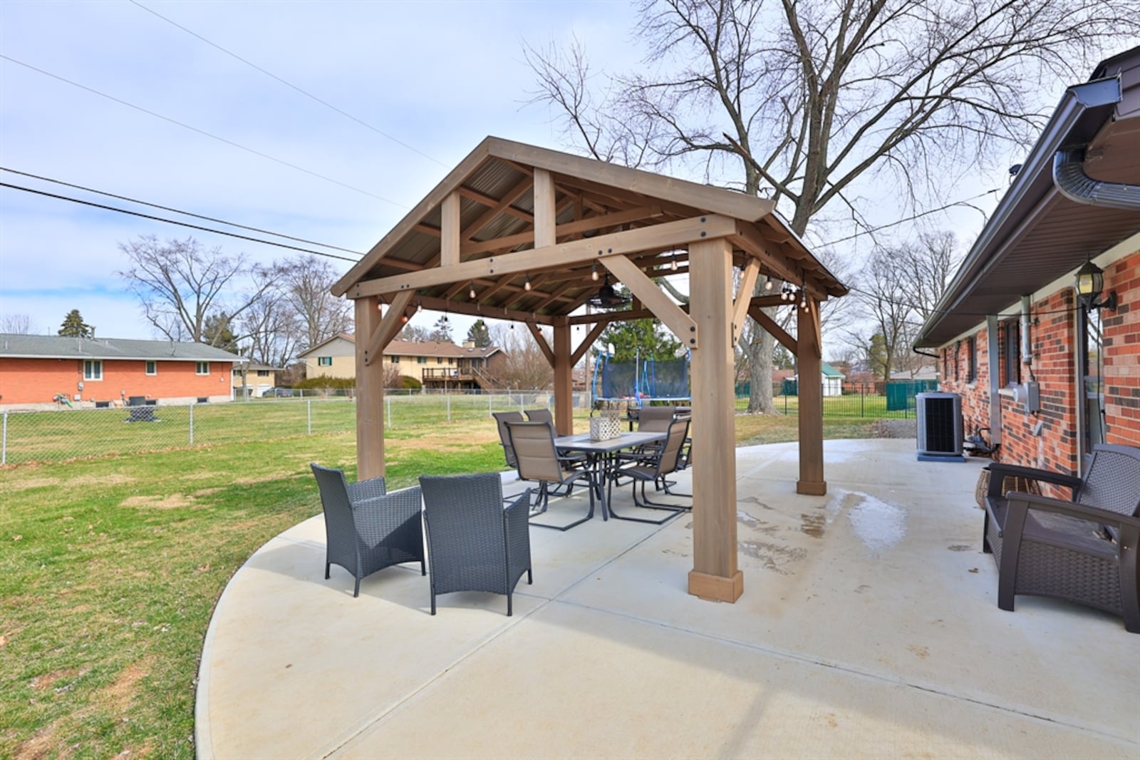 A concrete driveway leads up to the two-car garage and wraps around for extra off-street parking and continues into the backyard for an expanded patio. 