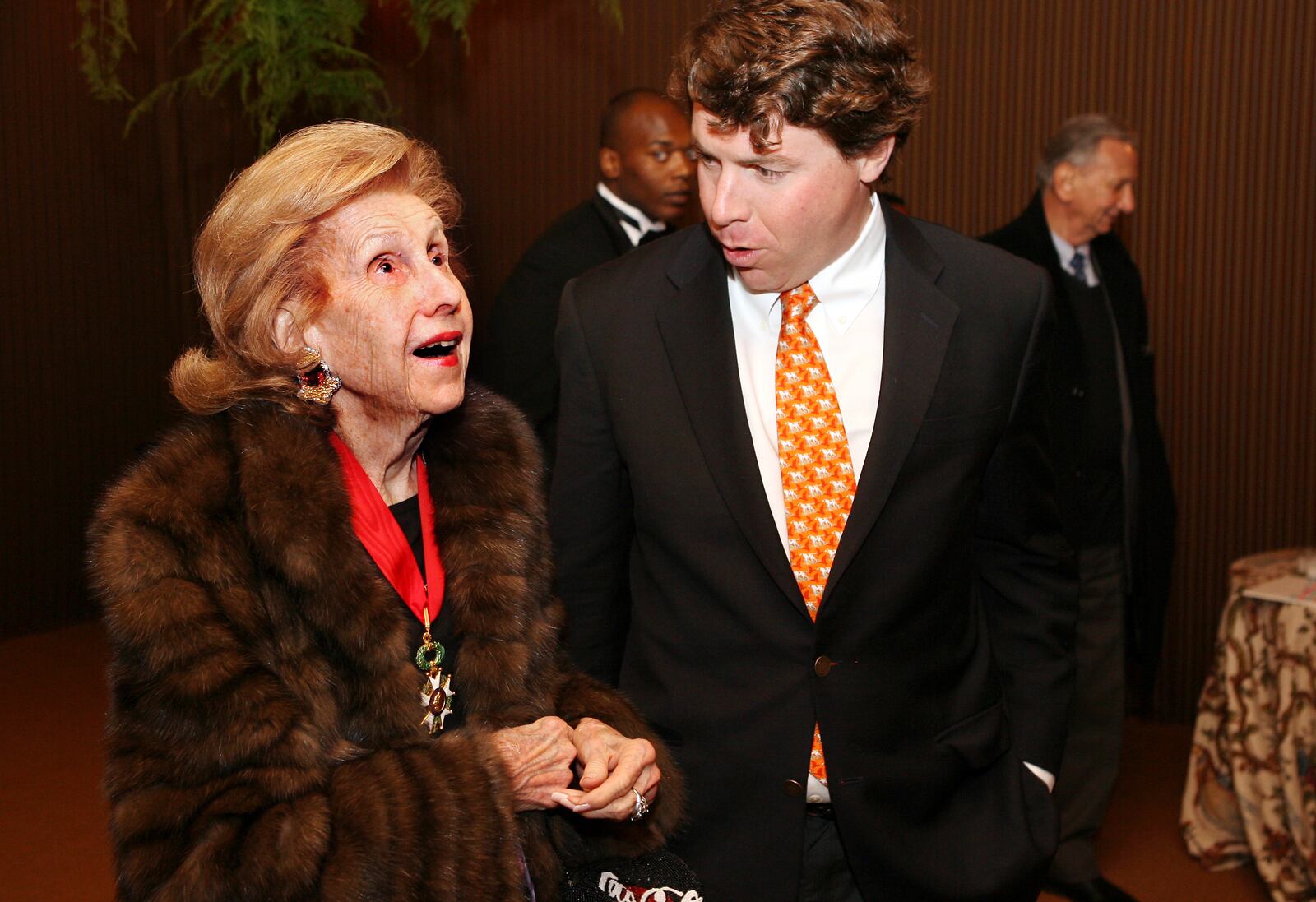 Anne Cox Chambers takes in the sites of her 90th birthday party, next to her grandson Alex Taylor, at the Cox Farm in Jacksonburg on Saturday, Dec. 5. This is Chambers' first trip back to the farm where she grew up in 52 years. She is the daughter of Dayton Daily News founder and former Ohio Gov. James M. Cox. The Cox Farm was built by Gilbert Cox in 1820. Staff photo by Nick Daggy