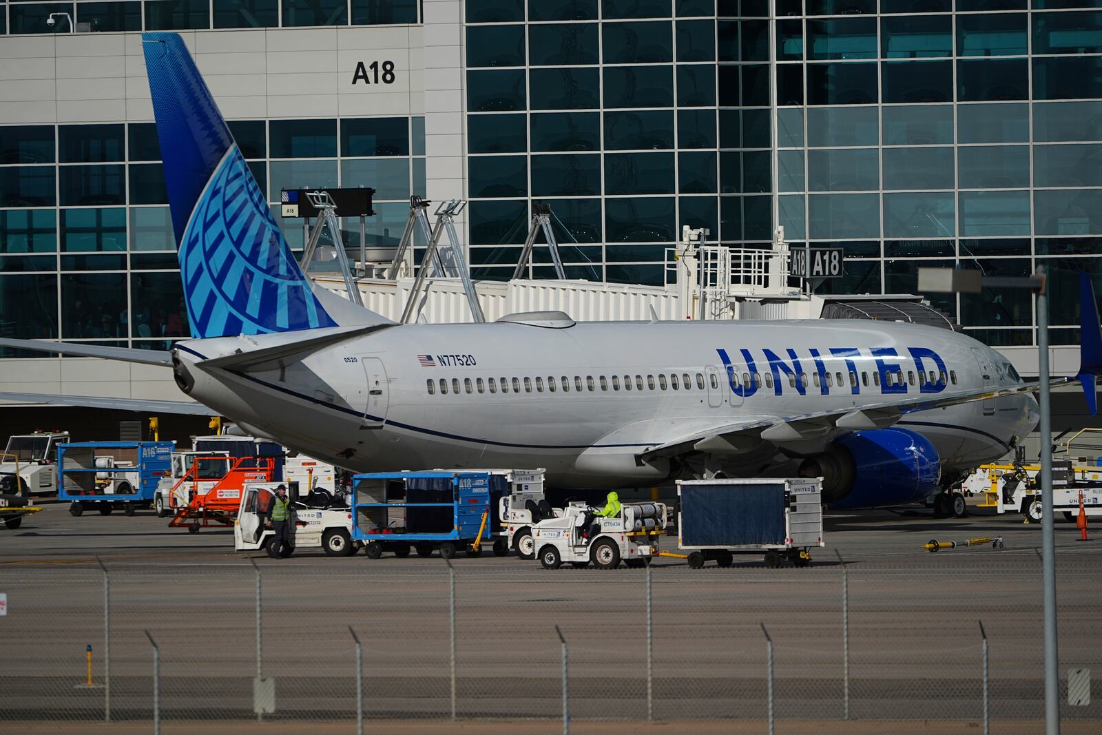 Workers prepare a United Airlines jetliner for departure from a gate on the A concourse at Denver International Airport Tuesday, Nov. 26, 2024, in Denver. (AP Photo/David Zalubowski)