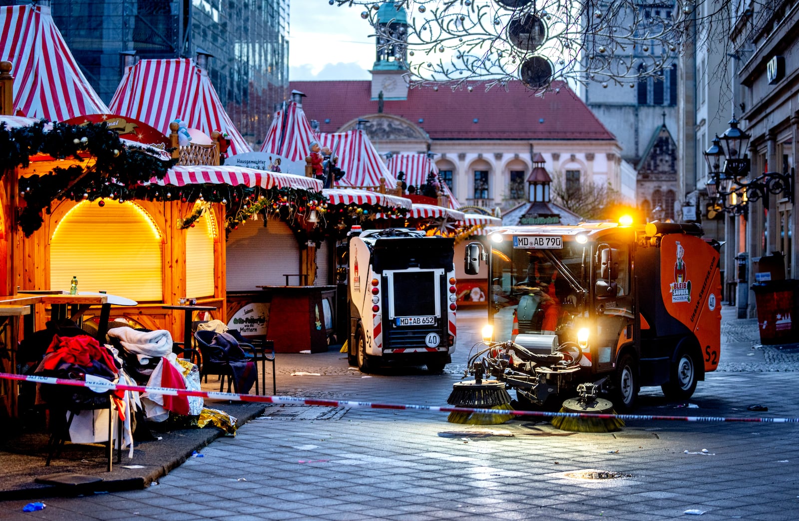 Public workers clean the Christmas Market, where a car drove into a crowd on Friday evening, in Magdeburg, Germany, is empty on Sunday morning , Dec. 22, 2024. (AP Photo/Michael Probst)