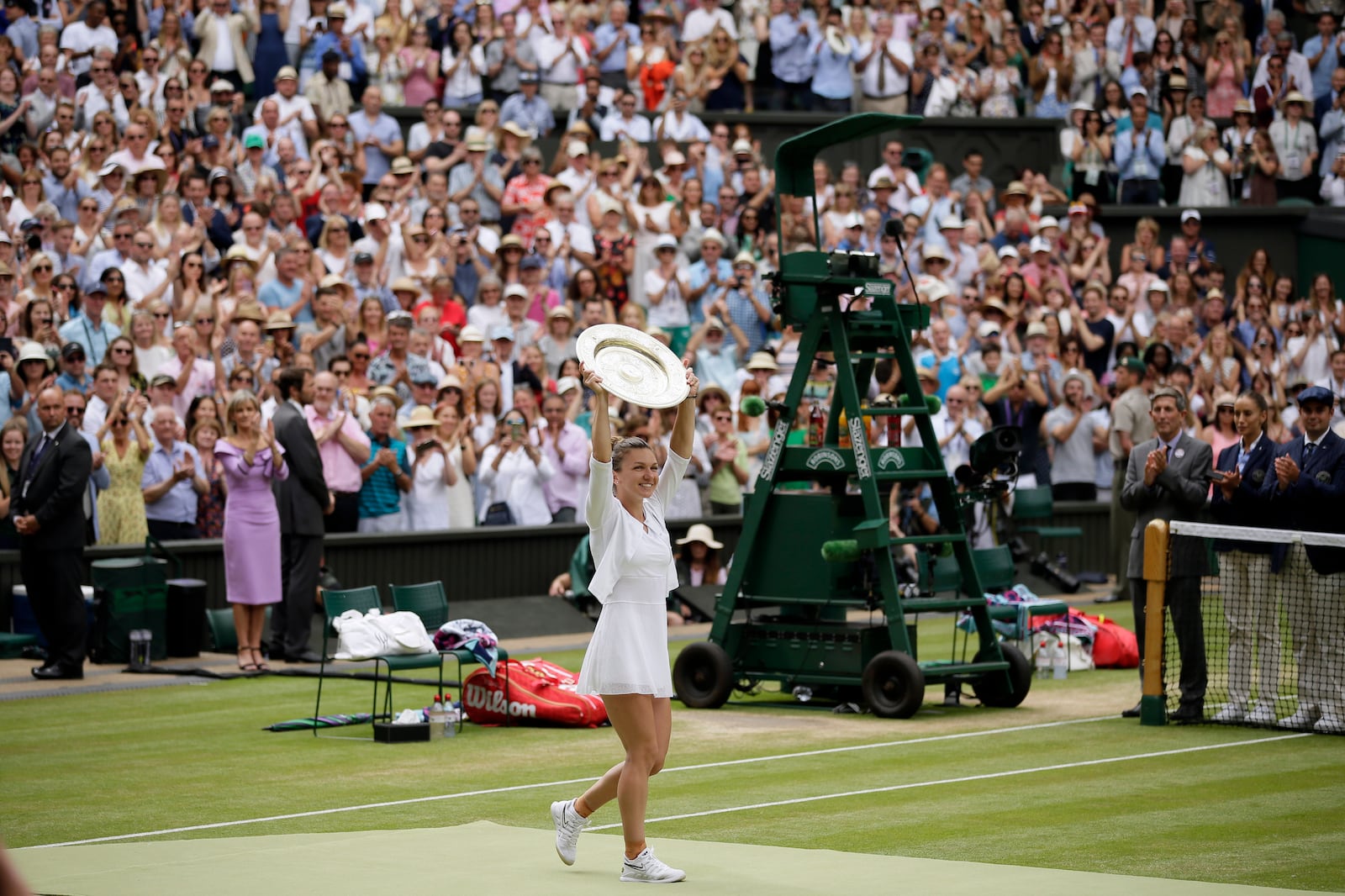 FILE - Romania's Simona Halep holds her trophy after defeating United States' Serena Williams in the women's singles final match on day twelve of the Wimbledon Tennis Championships in London, July 13, 2019. (AP Photo/Tim Ireland, file)