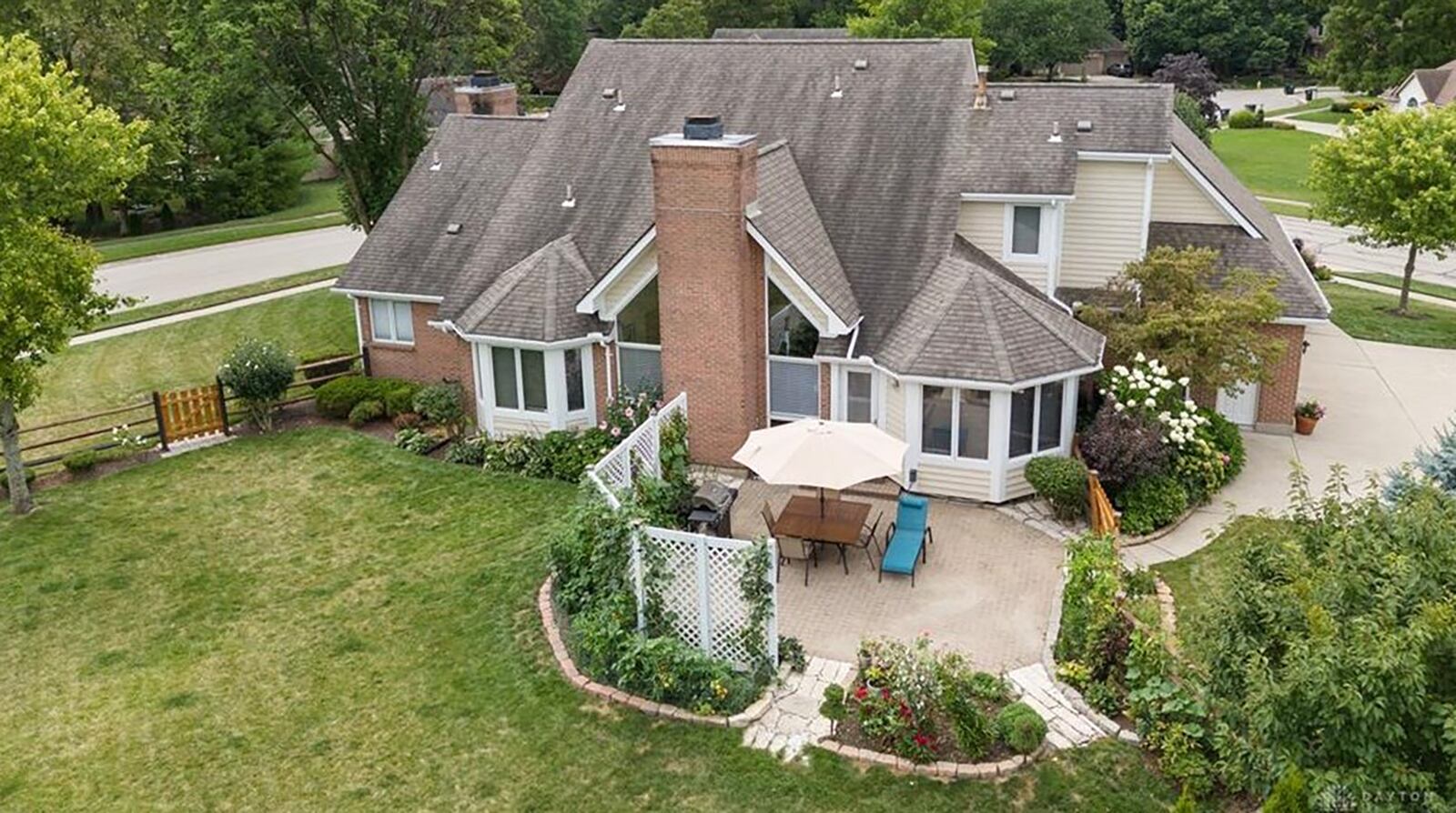 The rear of the home has a paver patio with lattice on one side for privacy, a wood fence and professional landscaping.