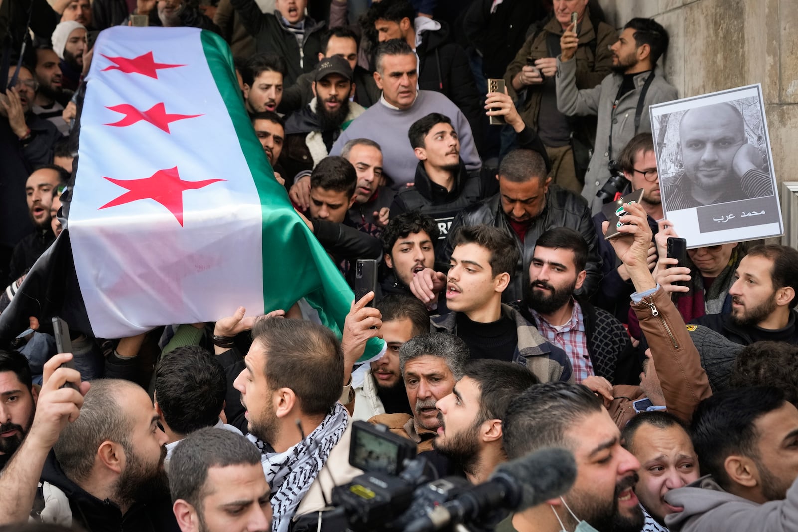 The coffin of Syrian activist Mazen al-Hamada is carried for burial in Damascus Thursday Dec. 12, 2024. Al-Hamad's mangled corpse was found wrapped in a bloody sheet in Saydnaya prison. He had fled to Europe but returned to Syria in 2020 and was imprisoned upon arrival. (AP Photo/Hussein Malla)