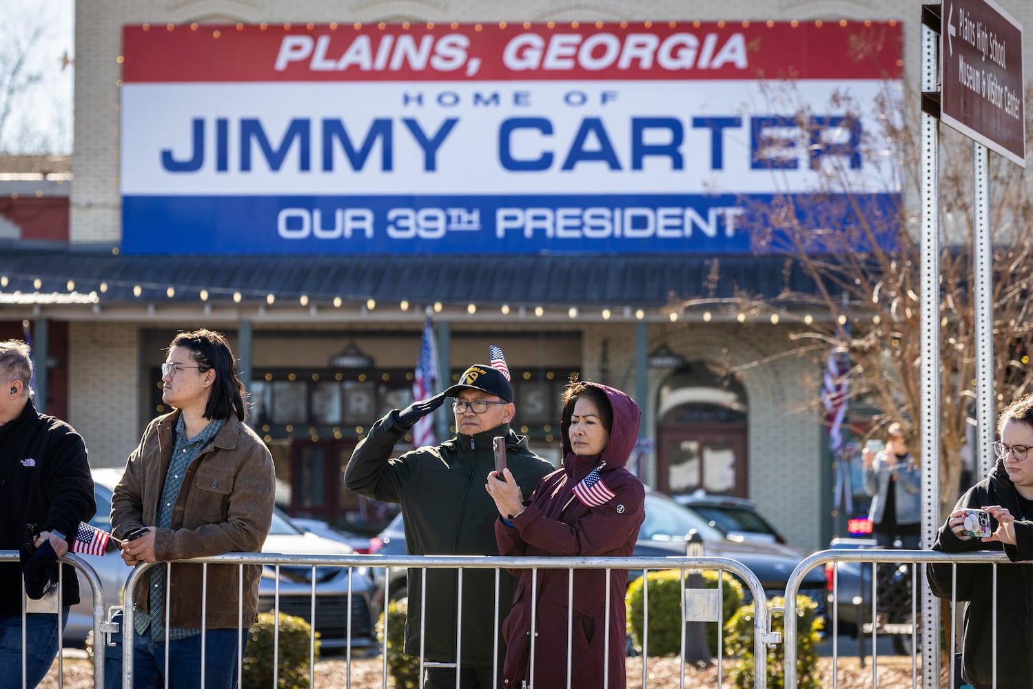 A man salutes as the hearse carrying the casket of former President Jimmy Carter moves through Plains, Ga., Saturday, Jan. 4, 2025. (Dustin Chambers/The New York Times)