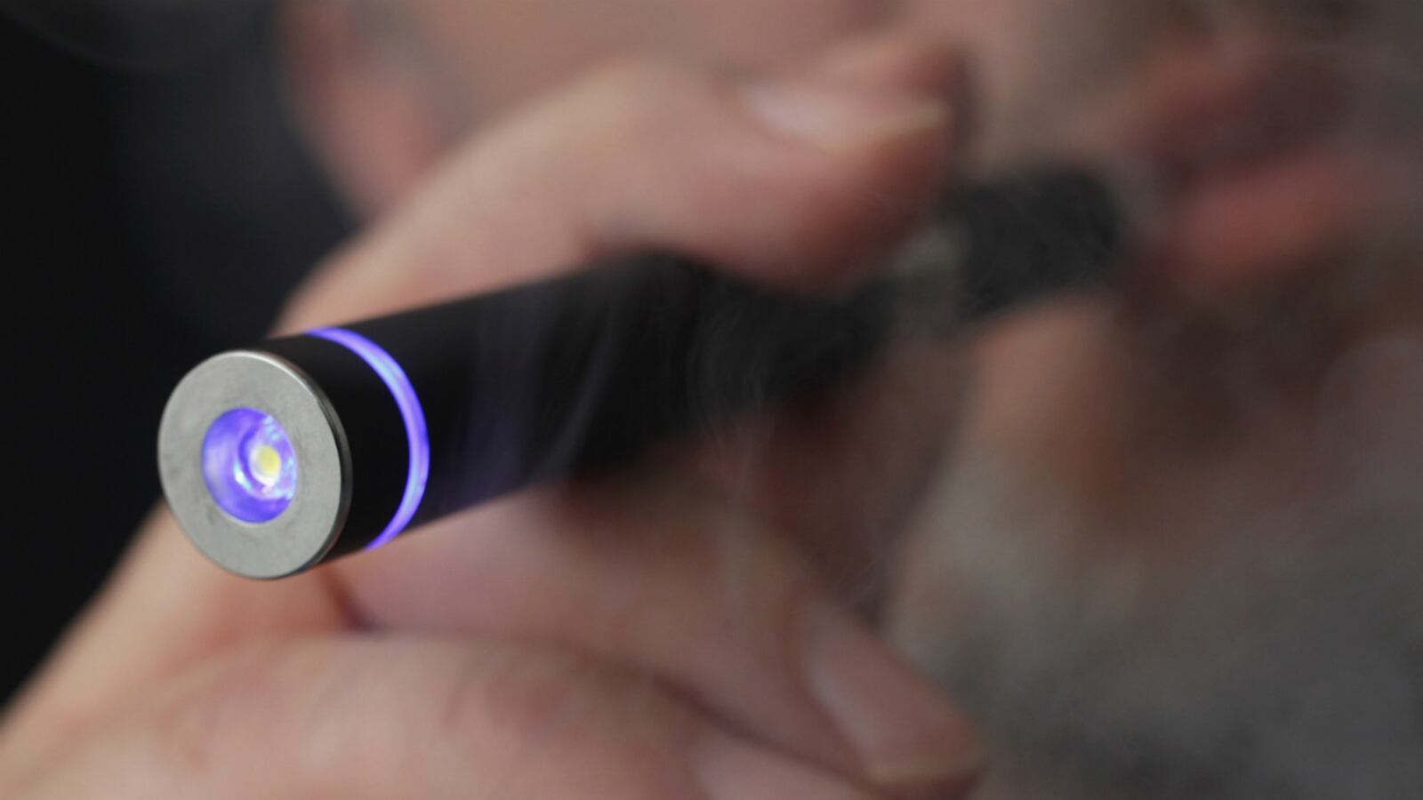 In this photo illustration the owner of a shop that sells electronic cigarettes demonstrates how to use one on March 1, 2012 in Berlin, Germany.