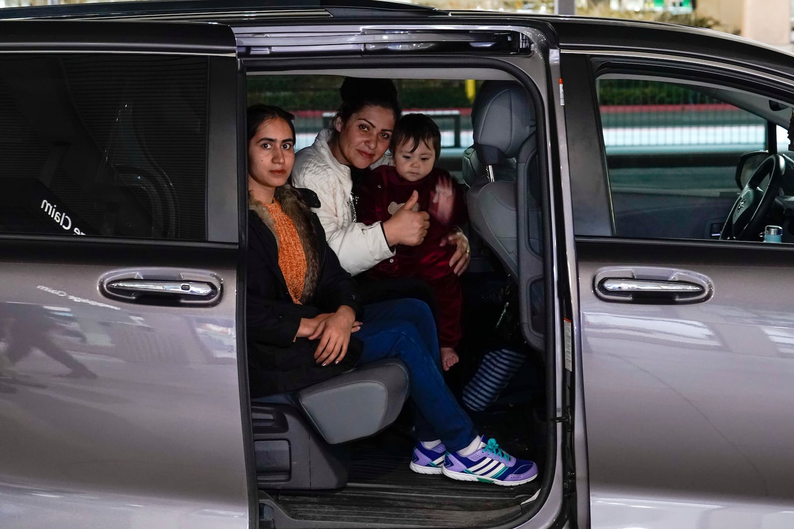 Noria Sdeqi, center and her two daughters, Mursal Omani, left and Sadaf Osmani, right, sit in a van that will take them from the Sacramento International Airport to their new California home, provided by the No One Left Behind Organization, Tuesday, March 11, 2025. (AP Photo/Rich Pedroncelli)