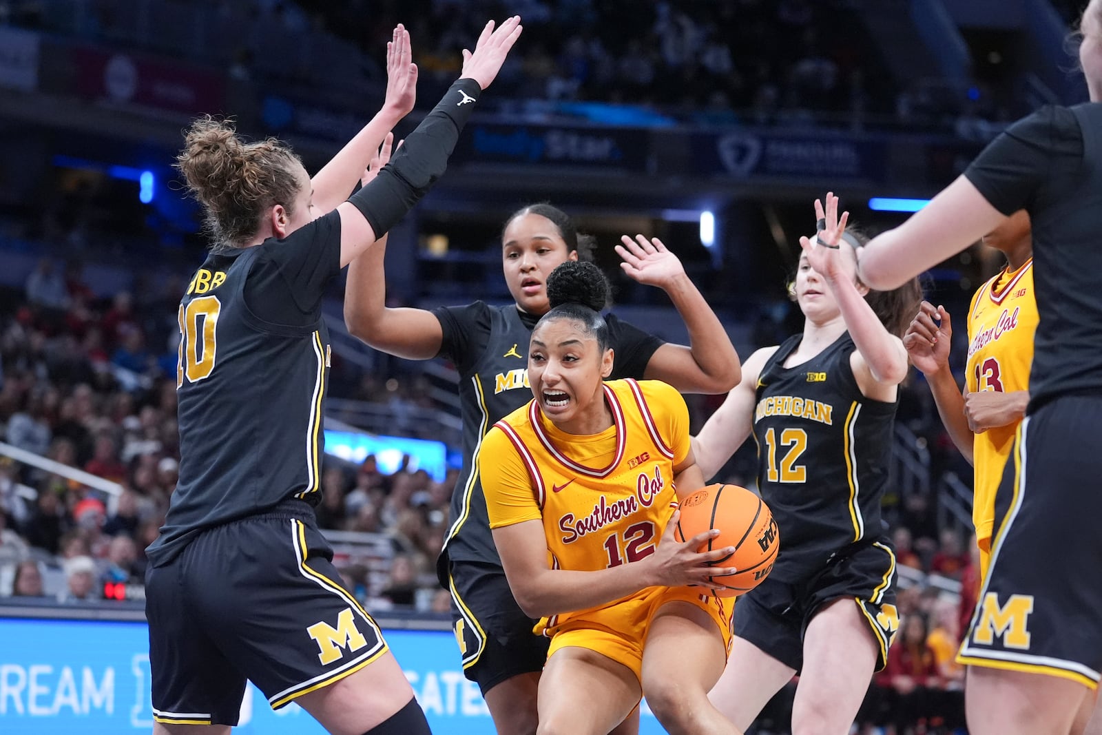 Southern California guard JuJu Watkins (12) drives on Michigan guard Jordan Hobbs (10) during the first half of an NCAA college basketball game in the semifinals of the Big Ten Conference tournament in Indianapolis, Saturday, March 8, 2025. (AP Photo/Michael Conroy)