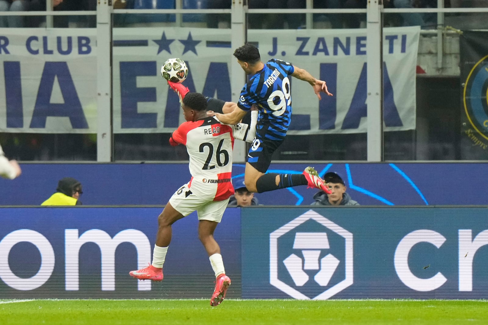 Feyenoord's Givairo Read, left, challenges for the ball with Inter Milan's Mehdi Taremi during a Champions League round of 16 second leg soccer match between Inter Milan and Feyenoord, at the San Siro stadium in Milan, Italy, Tuesday, March 11, 2025. (AP Photo/Luca Bruno)