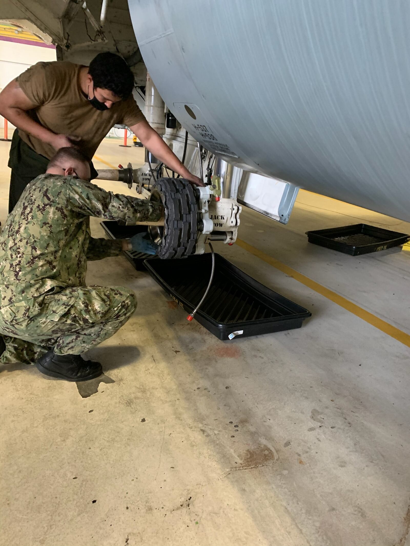 US Marine Corp technicians work on a C-130's wheels. Collins image