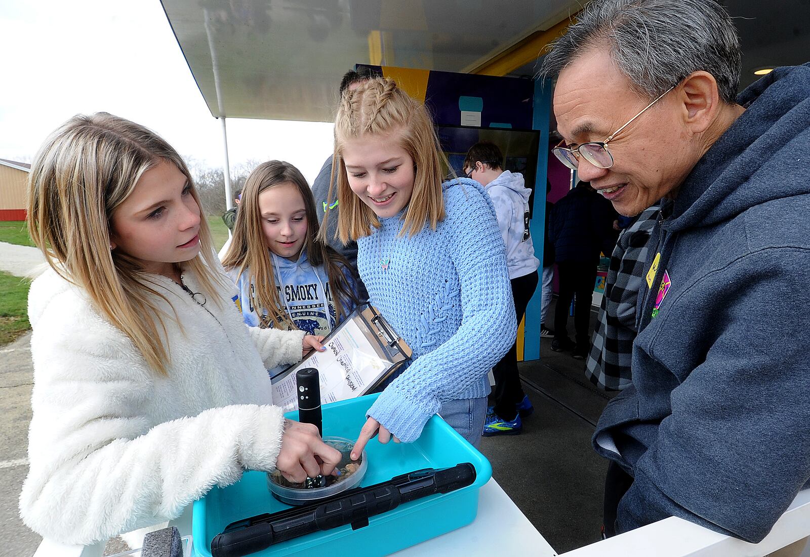 Miamisburg Middle School students from left, Emma Bush, Natilyn Jaynes and Allie Elswick talk with Wallach Lv at the Curiosity Cube mobile science lab at the school Tuesday March 28, 2023. MilliporeSigma is engaging students in STEM learning through its Curiosity Cube mobile science lab. The Curiosity Cube is designed to spark scientific curiosity and passion early—paving the way to a future filled with innovative breakthroughs and encouraging students to pursue careers in STEM fields. It also brings interactive science experiences and tools to students who might not otherwise have access, such as those attending schools with fewer resources. MARSHALL GORBY\STAFF