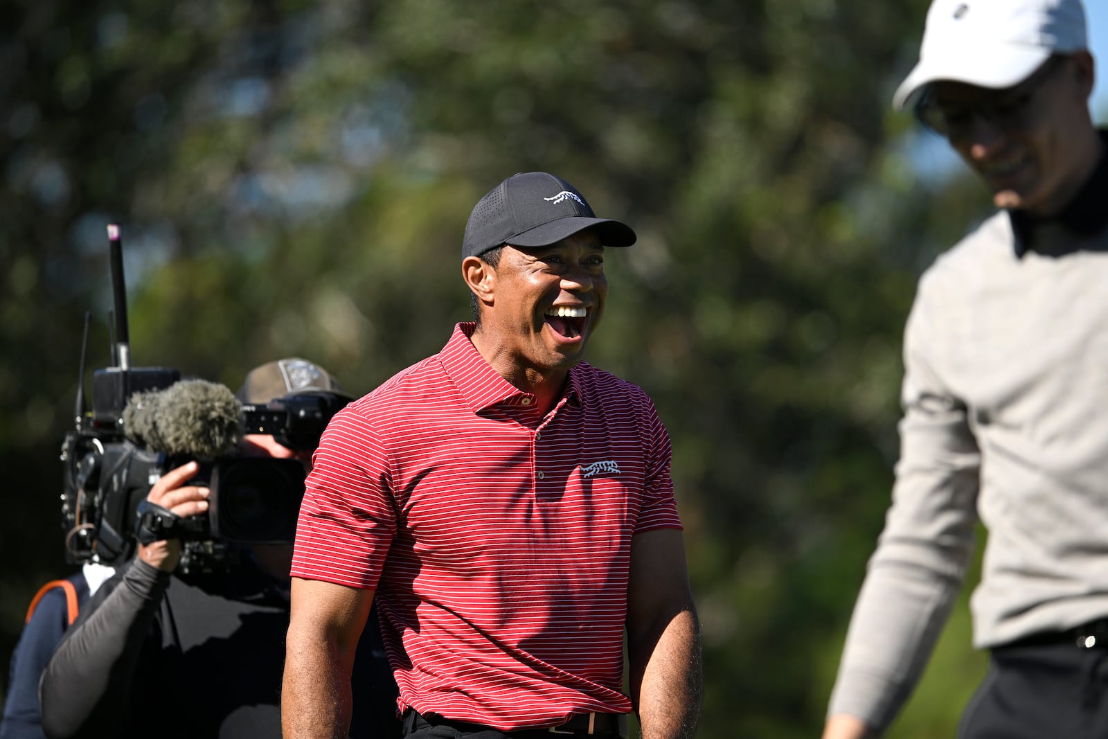 Tiger Woods, center, reacts to his son Charlie Wood's hole-in-one on the fourth hole during the final round of the PNC Championship golf tournament, Sunday, Dec. 22, 2024, in Orlando, Fla. (AP Photo/Phelan M. Ebenhack)