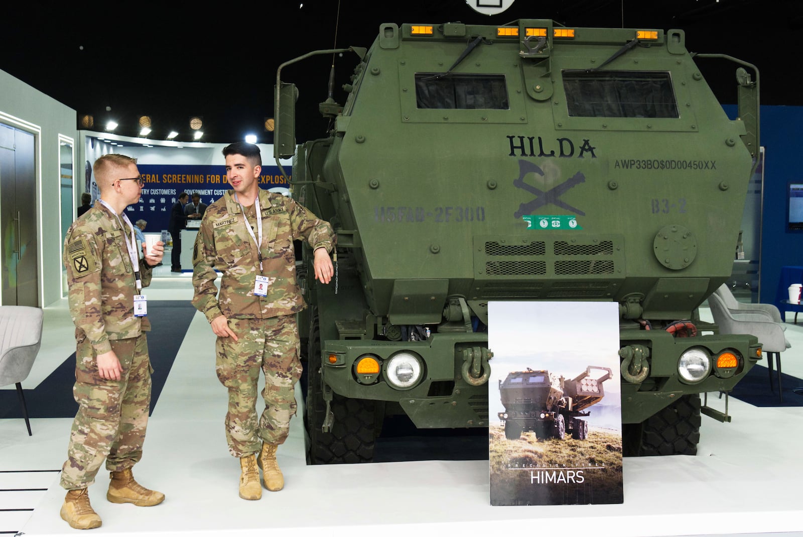 Two U.S. soldiers stand by a HIMARS weapon system on display at the biennial International Defense Exhibition and Conference arms show in Abu Dhabi, United Arab Emirates, Monday, Feb. 17, 2025. (AP Photo/Jon Gambrell)