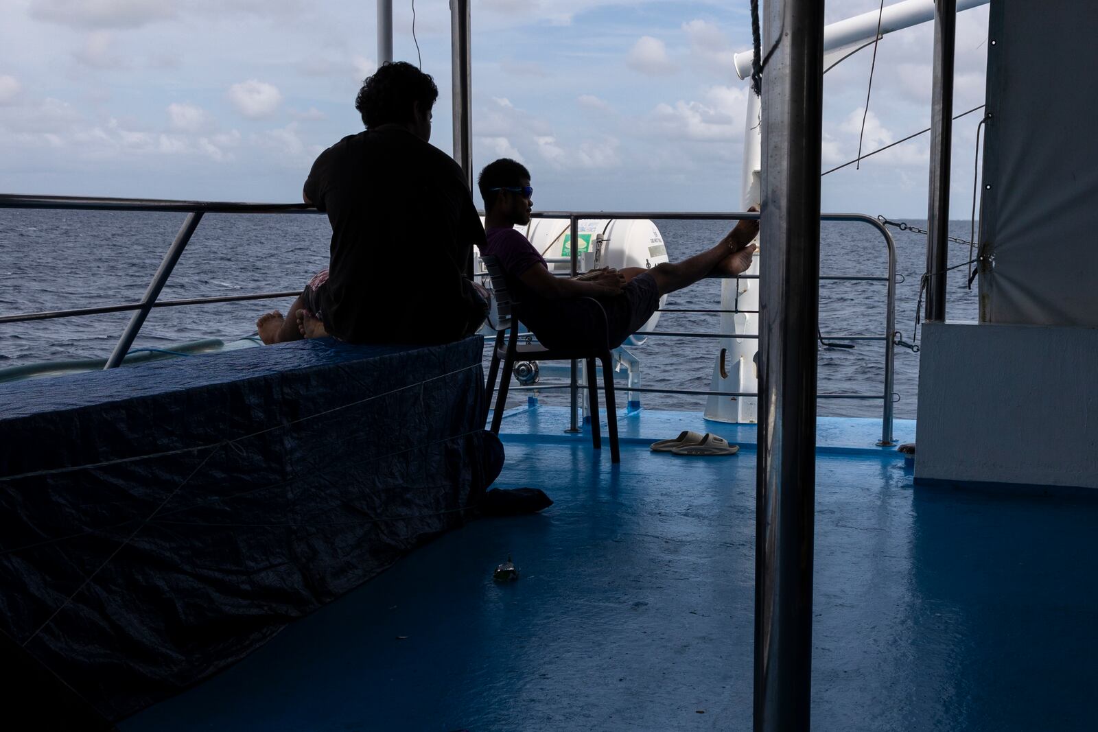 Maxson Blesson, left, and Carson Ngiralbong, a ranger for the Hatohobei State Rangers, lounge on the second level of the Ryoma, a boat that brings goods through the Pacific Ocean to Helen Island, Palau on July 17, 2024. (AP Photo/Yannick Peterhans)