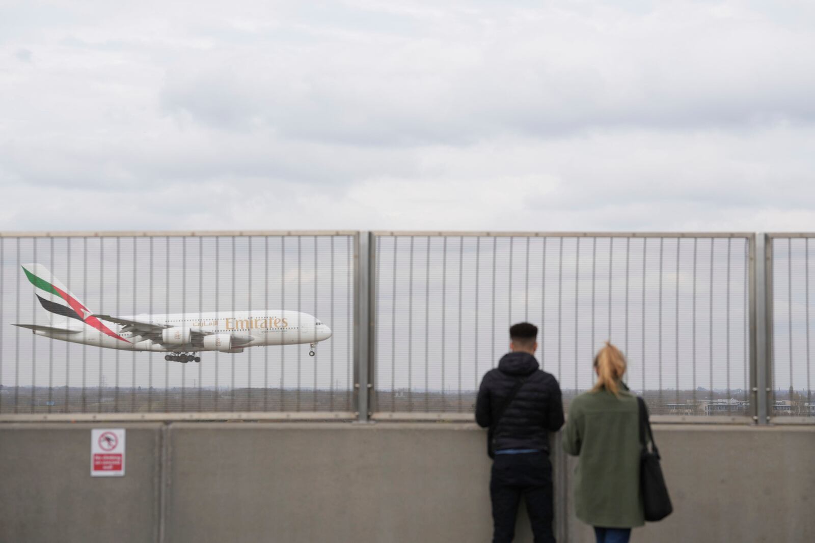 People watch an Emirates plane at Heathrow Airport in London on Saturday March 22, 2025, after flights resumed at the west London airport on Friday evening. (Maja Smiejkowska/PA via AP)