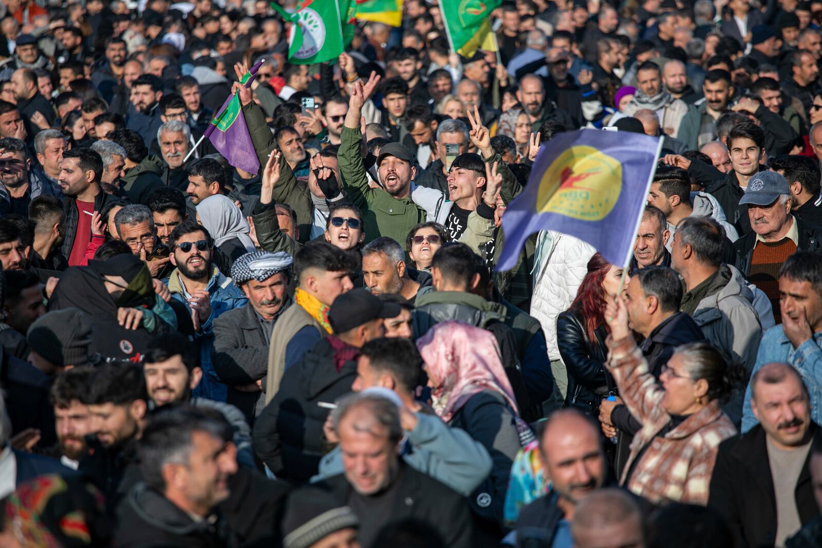 People gather to watch live on a tv screen a Pro-Kurdish Peoples' Equality and Democracy Party, or DEM, delegation members releasing an statement from the jailed leader of the rebel Kurdistan Workers' Party, or PKK, Abdullah Ocalan, in Diyarbakir, Turkey, Thursday, Feb. 27, 2025. (AP Photo/Metin Yoksu)