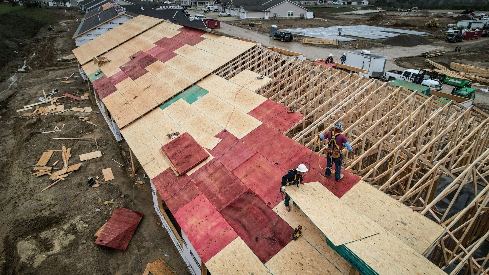 Workers install a roof on an apartment complex called Redwood Apartment Neighborhoods on Umberoak Drive in Miamisburg Wednesday, April 10, 2024. Total new permits pulled for 2023 numbered 1,697, down 14.8% from 2022, according to Home Builders Association of Dayton. JIM NOELKER/STAFF