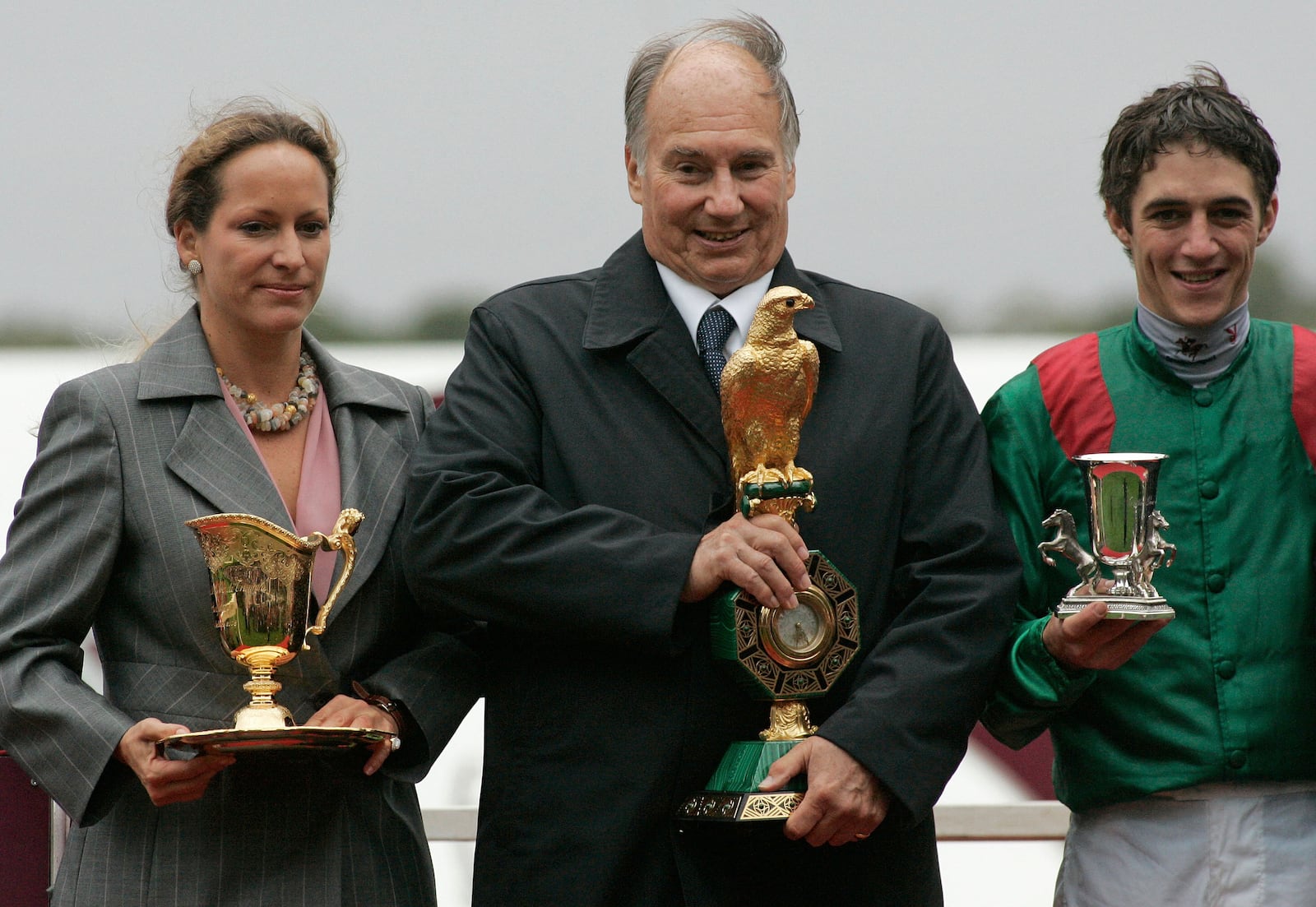 FILE - The owner of Zarkava his highness Aga Khan, center, his daughter Zahra Aga Khan, left, and French jockey Christophe Soumillon hold their trophies after winning the Prix de l'Arc de Triomphe horse race at Longchamp race track in Paris, Sunday, Oct. 5, 2008. (AP Photo/Michel Euler, File)