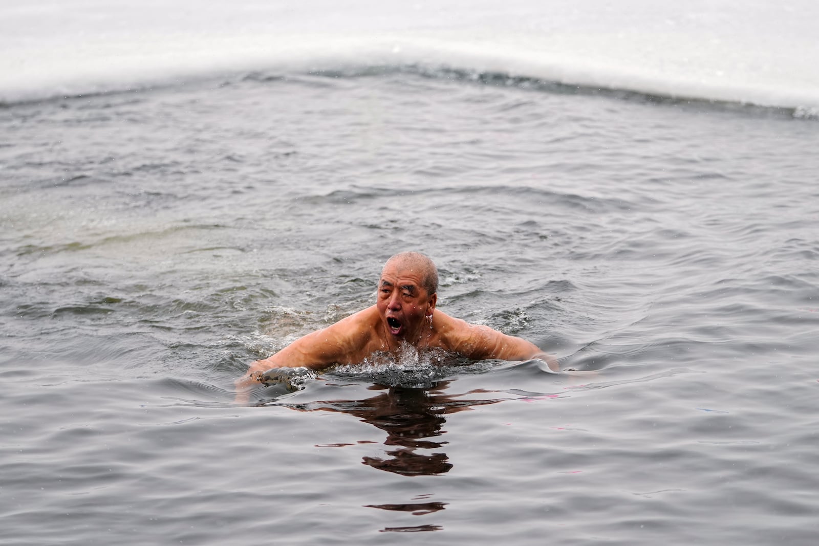 A man swims in a pool carved from ice on the frozen Songhua river in Harbin in northeastern China's Heilongjiang province, Tuesday, Jan. 7, 2025. (AP Photo/Andy Wong)