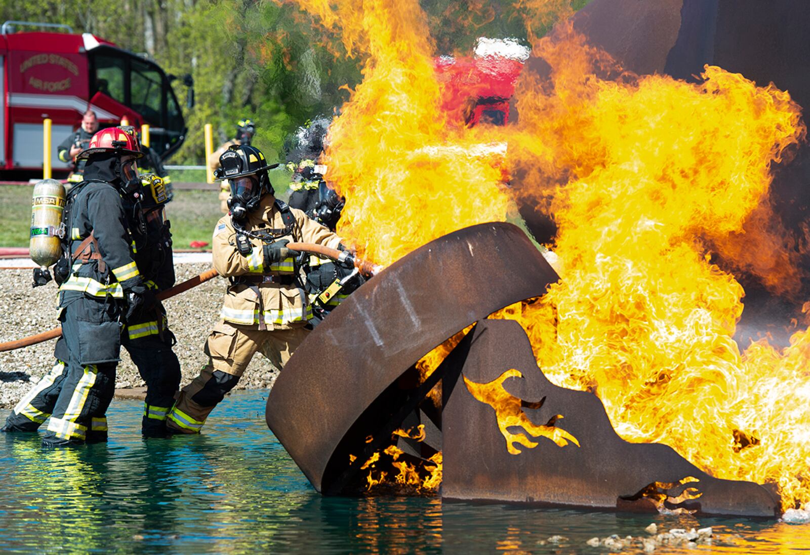 Firefighters from the 788th Civil Engineer Squadron fire department, Dayton Airport fire department, and Vandalia, Ohio, fire department, spray a fire on an aircraft training fuselage at Wright-Patterson Air Force Base April 26. U.S. AIR FORCE PHOTO/WESLEY FARNSWORTH