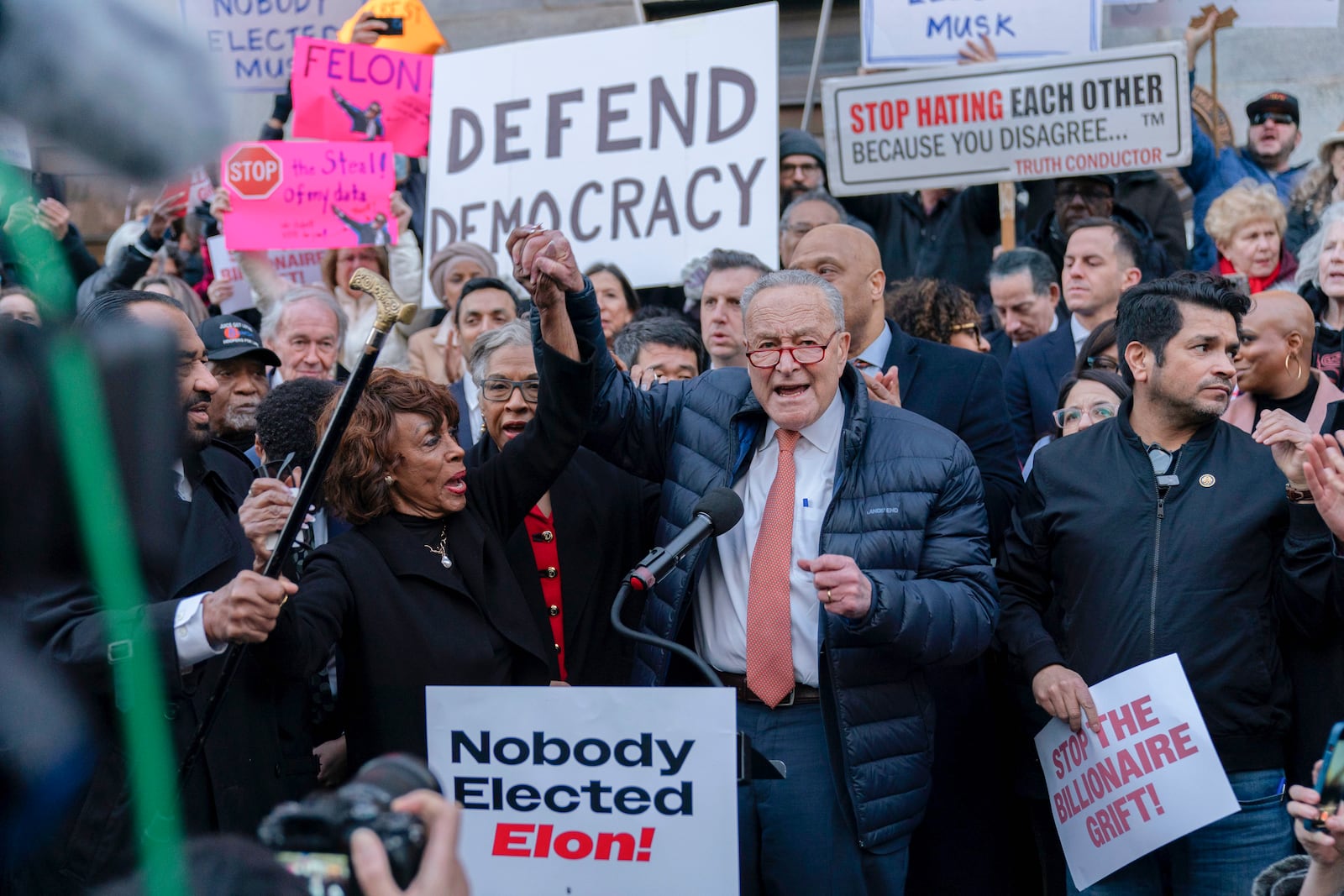 Senate Minority Leader Chuck Schumer, D-N.Y., holding hands with Rep. Maxine Waters, D-Calif., accompanied by other members of Congress, speaks during a rally against Elon Musk outside the Treasury Department in Washington, Tuesday, Jan. 30, 2025. (AP Photo/Jose Luis Magana)