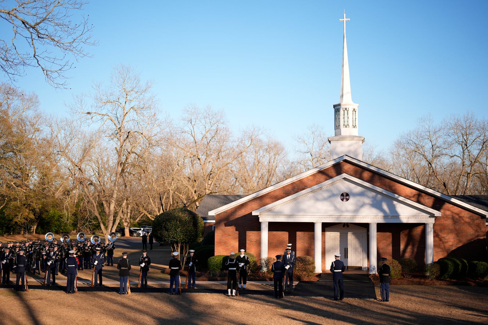 An honor guard and honor guard band march before the casket of former President Jimmy Carter arrives at Maranatha Baptist Church for a funeral service, Thursday, Jan. 9, 2025, in Plains, Ga. (AP Photo/Mike Stewart)