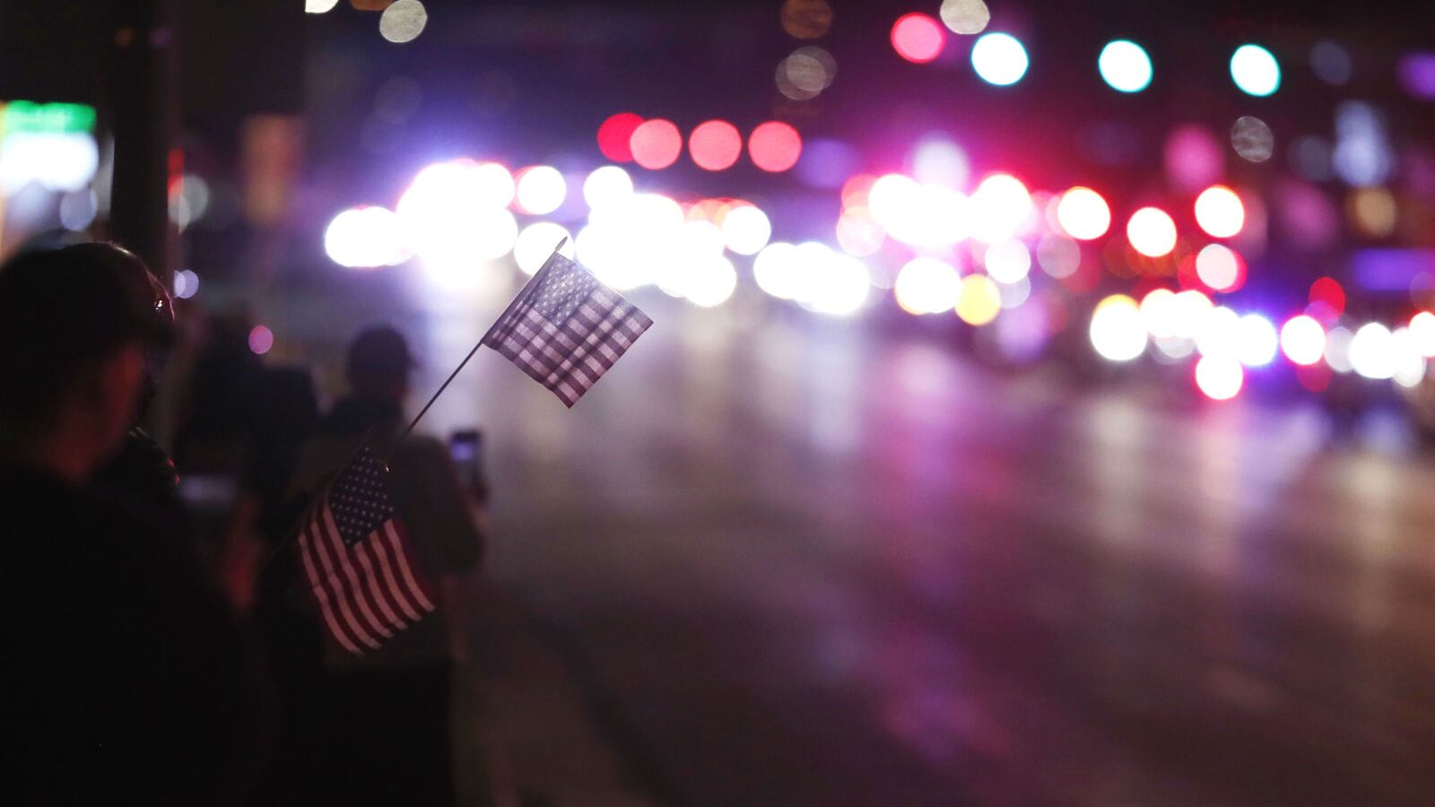 Denver residents pay tribute to paramedic Paul Cary on Sunday, May 3, 2020, as the procession carrying his body passes by. Cary, 66, died Thursday, April 30, of coronavirus complications after volunteering to help combat the pandemic in New York City. (AP Photo/David Zalubowski)