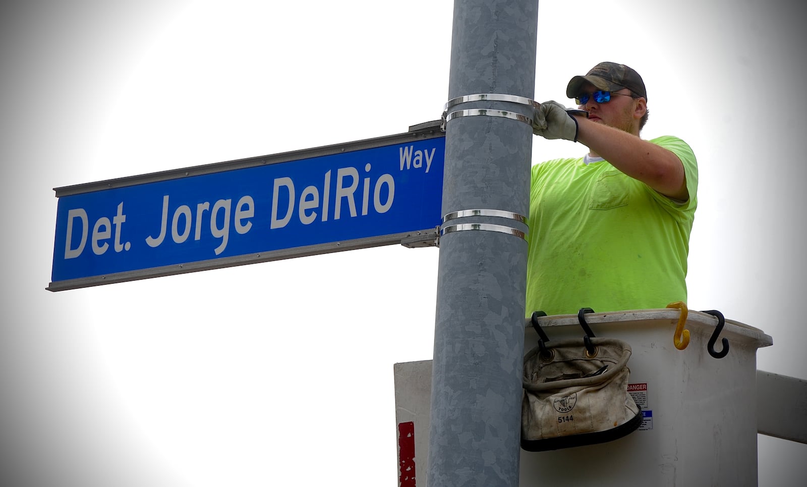 Trip Ward, an employee for the city of Dayton, installs a sign at the intersection of Monument Avenue and Patterson Boulevard that is being dedicated to fallen Dayton police detective Jorge DelRio Thursday, June 10, 2021. MARSHALL GORBY\STAFF