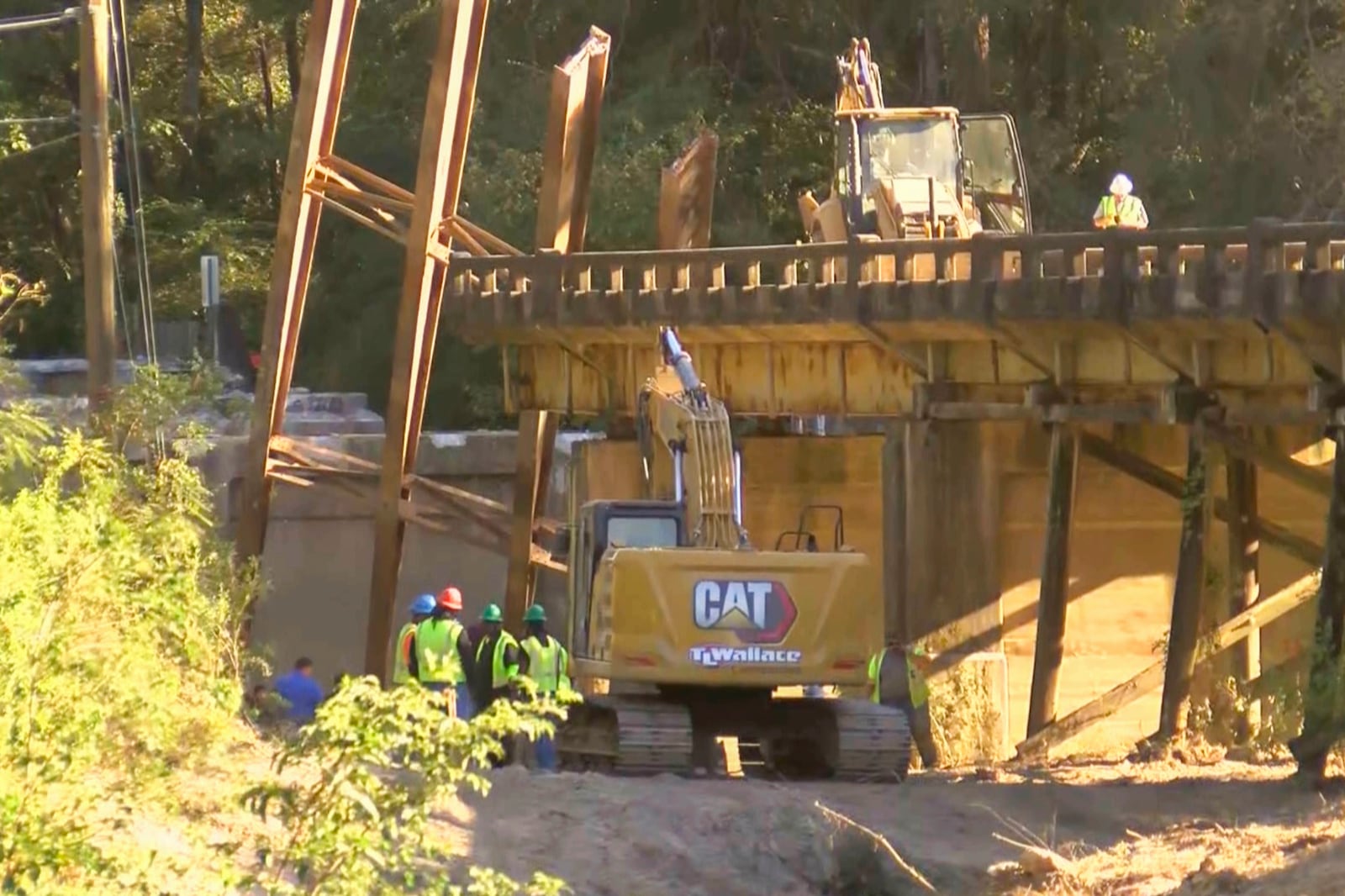 This image taken from video from WLBT shows construction workers at the scene after a bridge over the Strong River on State Route 149 in Simpson County, Miss., collapsed on Wednesday, Oct. 16, 2024. (WLBT via AP)