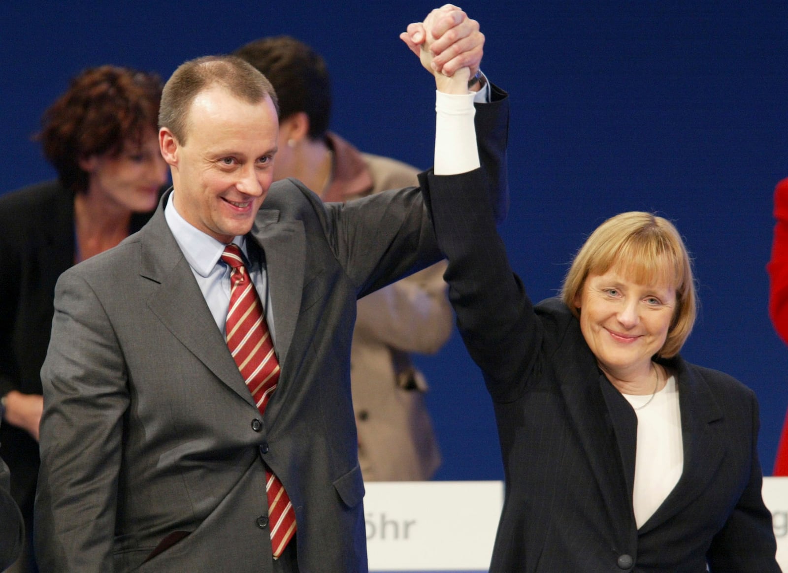 FILE - Floor leader Friedrich Merz, left, and Angela Merkel, chairwoman of the Christian Democrats Union party (CDU), cheer after Merz's speech to the delegates of the CDU party convention in Dresden, Germany, Dec. 4, 2001. (AP Photo/Eckehard Schulz, File)