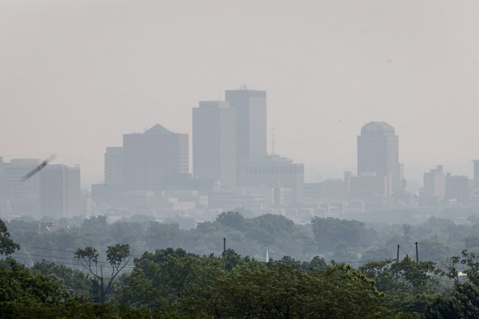 Persisting smoke from Canadian wildfires, shown shrouding downtown Dayton on Tuesday, June 6, 2023, has caused air pollution and extended air quality alerts for the region. JIM NOELKER/STAFF