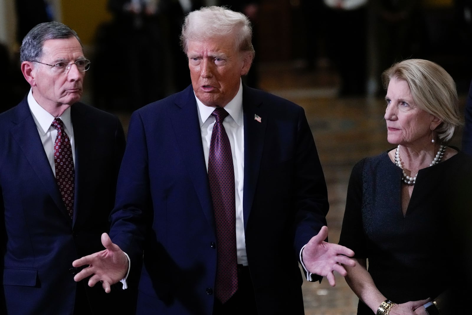 President-elect Donald Trump, flanked by Sen. John Barrasso, R-Wyo., left, Sen. Shelley Moore Capito, R-W.Va., right, talks to reporters after a meeting with Republican leadership at the Capitol on Wednesday, Jan. 8, 2025, in Washington. (AP Photo/Steve Helber)